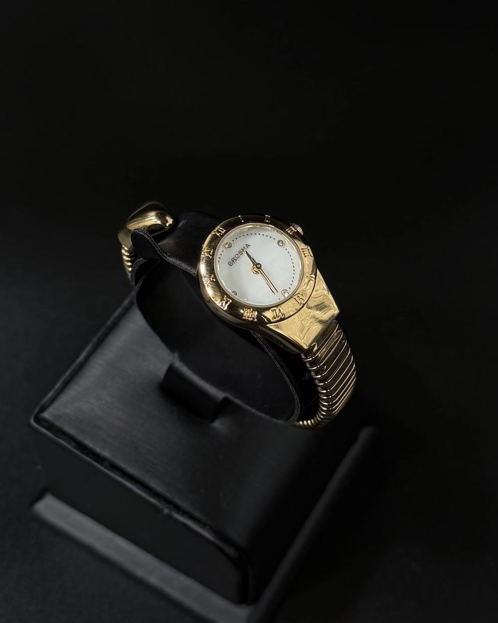 A women's watch with a delicate design and an open strap.