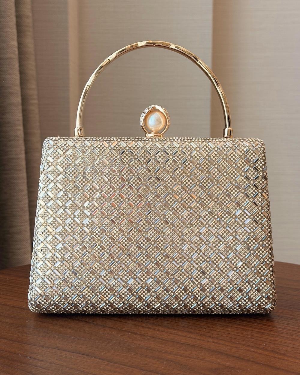 Evening bag with a round handle decorated with a pearl