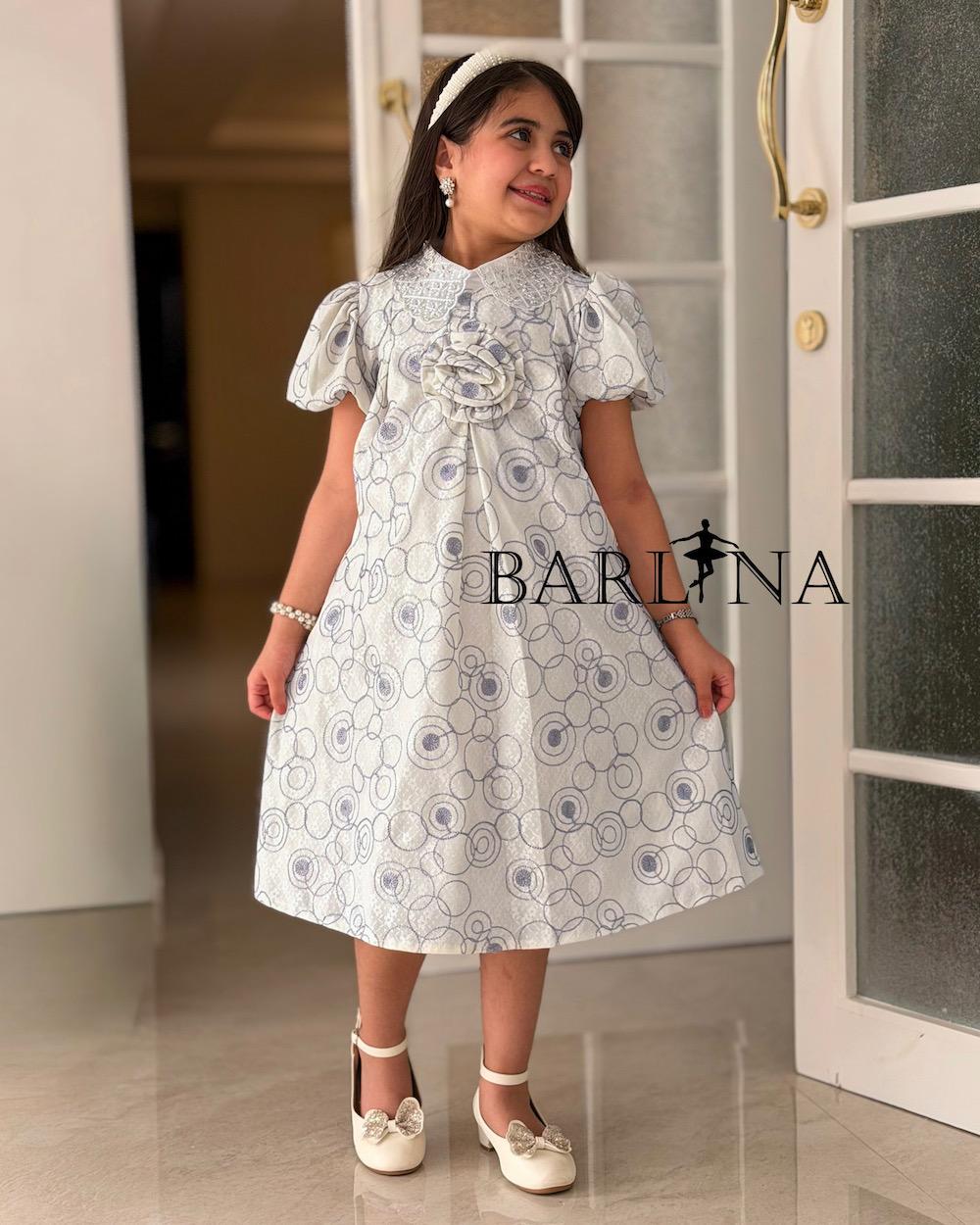 A girl's dress decorated with circle patterns and a raised rose