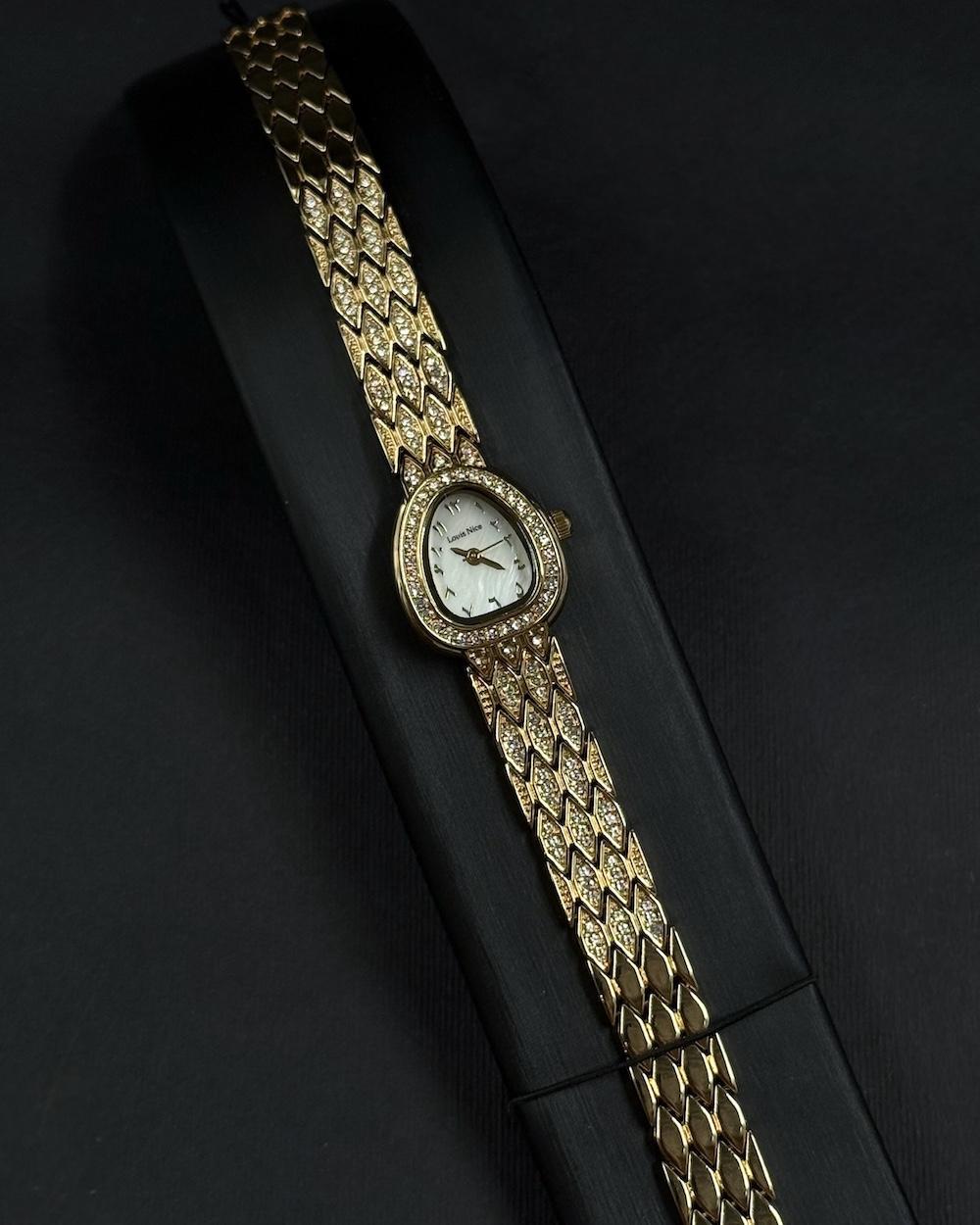 A luxury watch with a geometrically designed studded bracelet.
