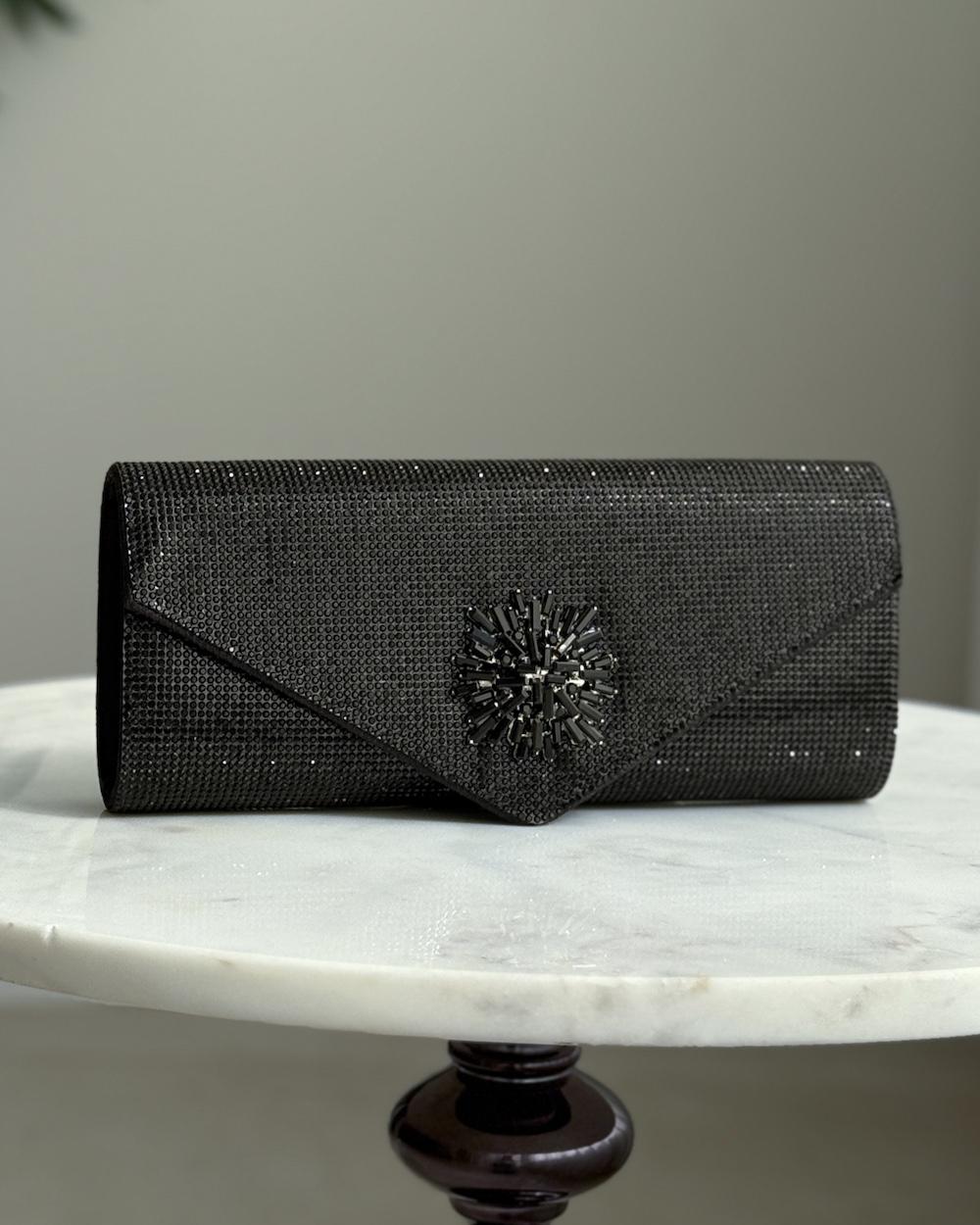 An elegant evening bag with a prominent central embellishment.