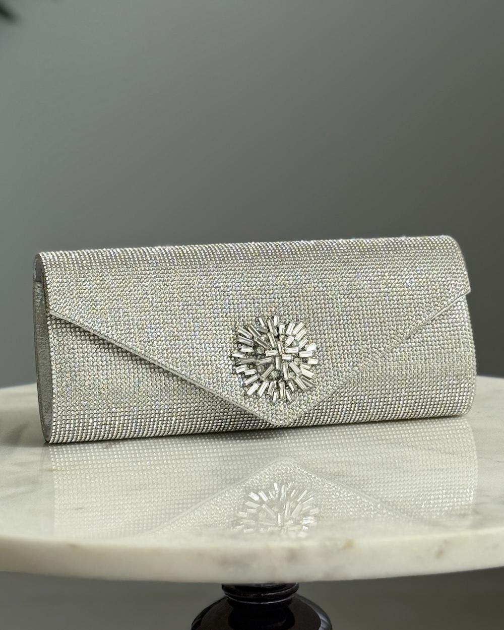 An elegant evening bag with a prominent central embellishment.