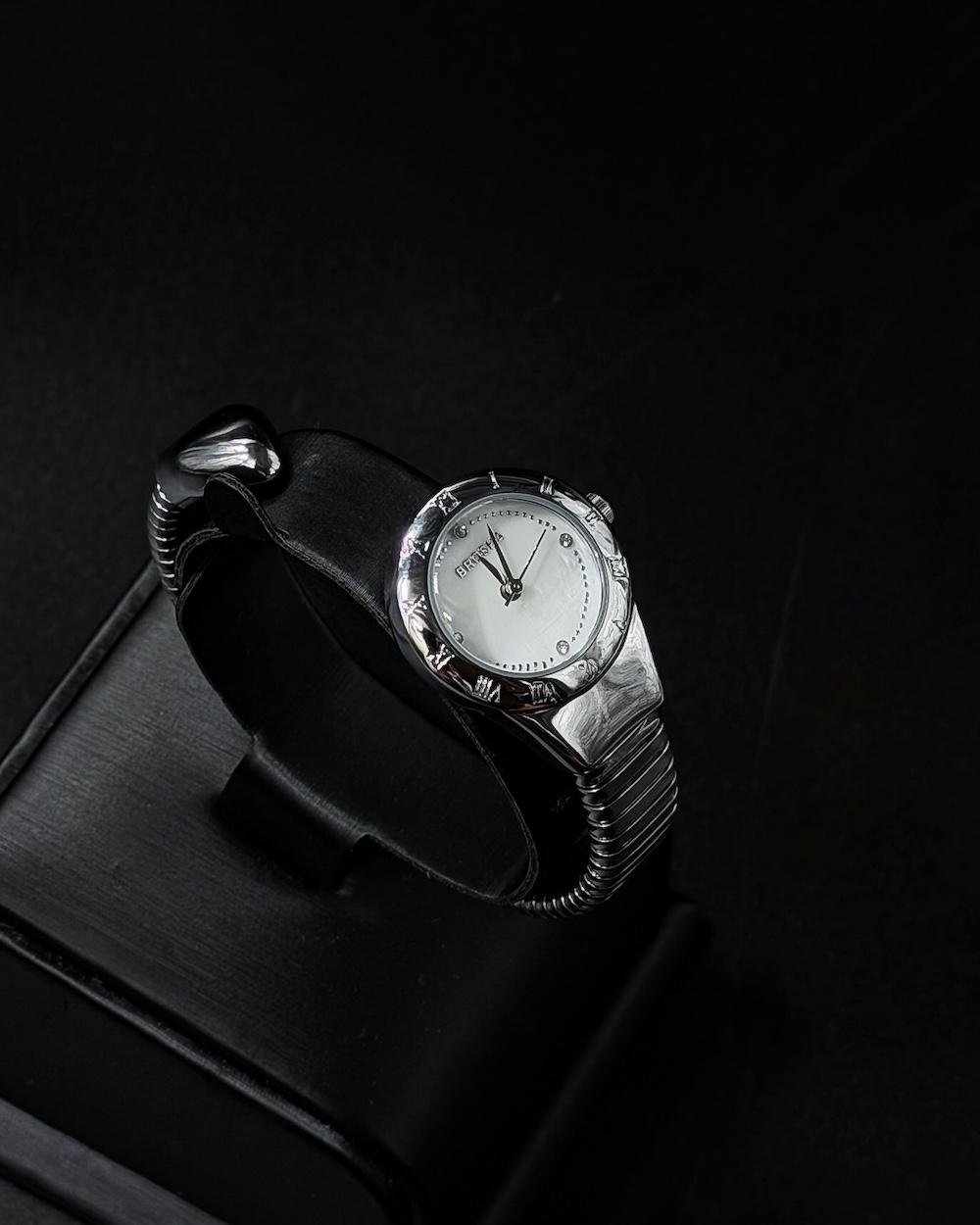 A women's watch with a delicate design and an open strap.