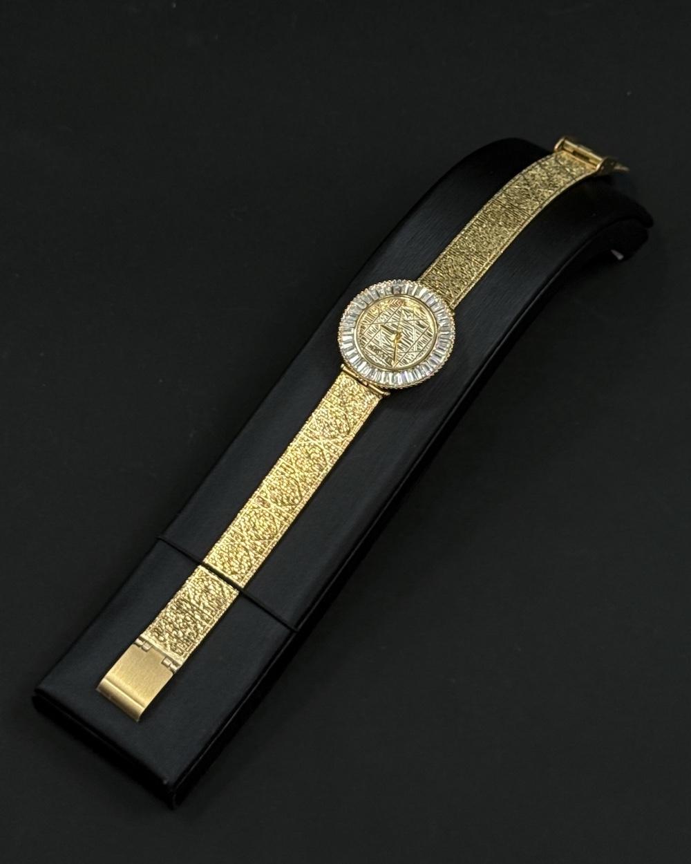 A women's watch adorned with a frame and engraved details