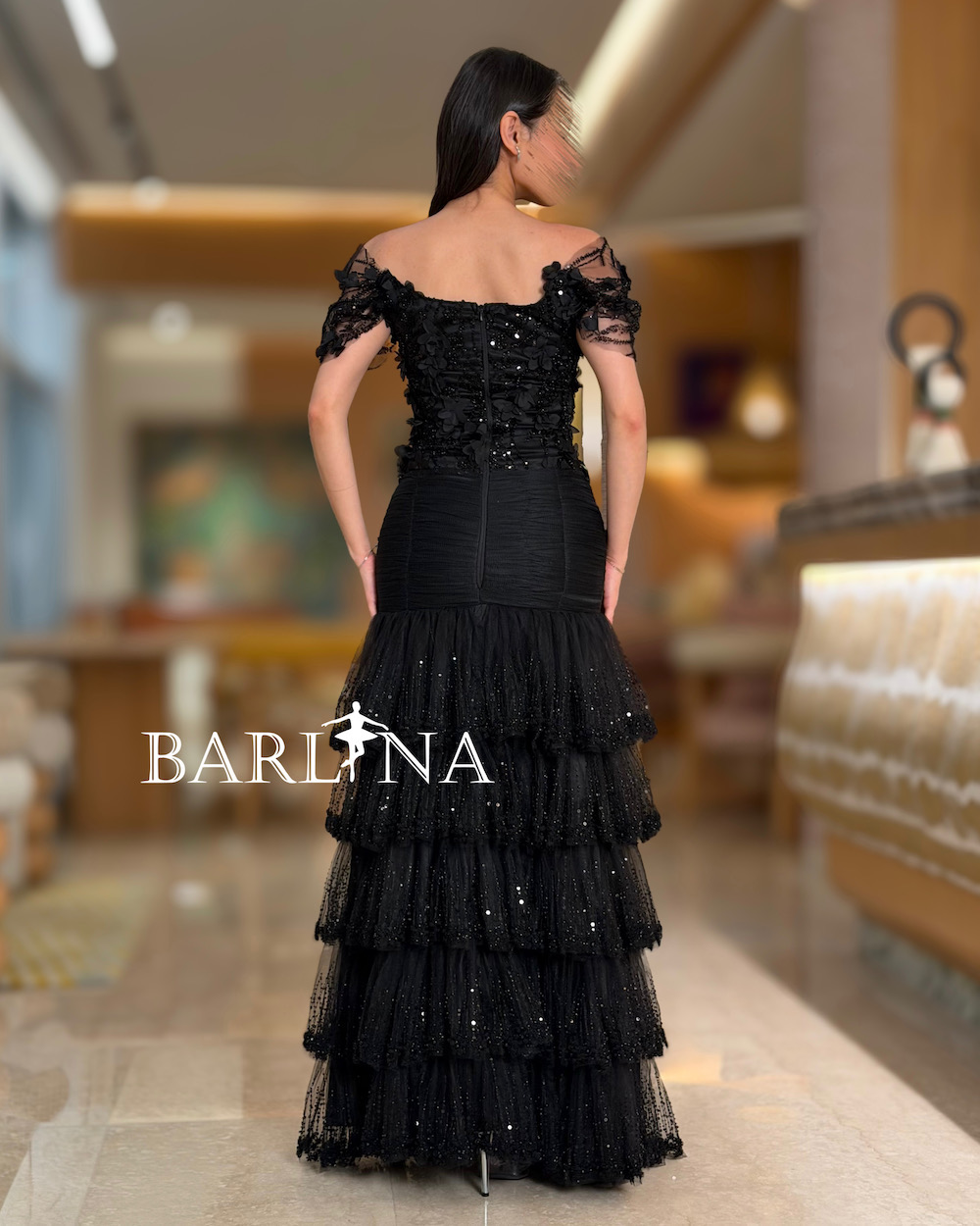 A black dress with tulle layers and embroidered details.