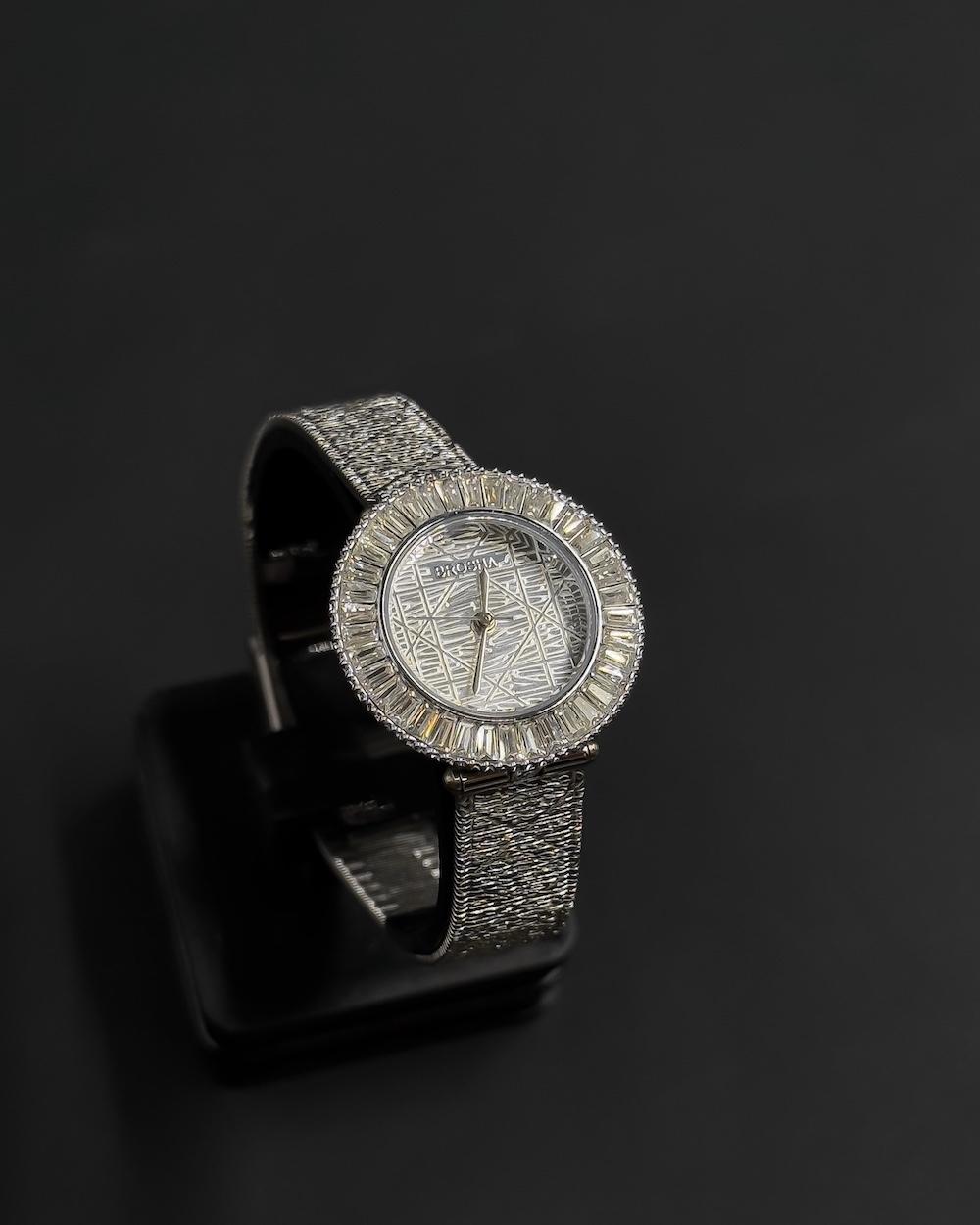 A women's watch adorned with a frame and engraved details