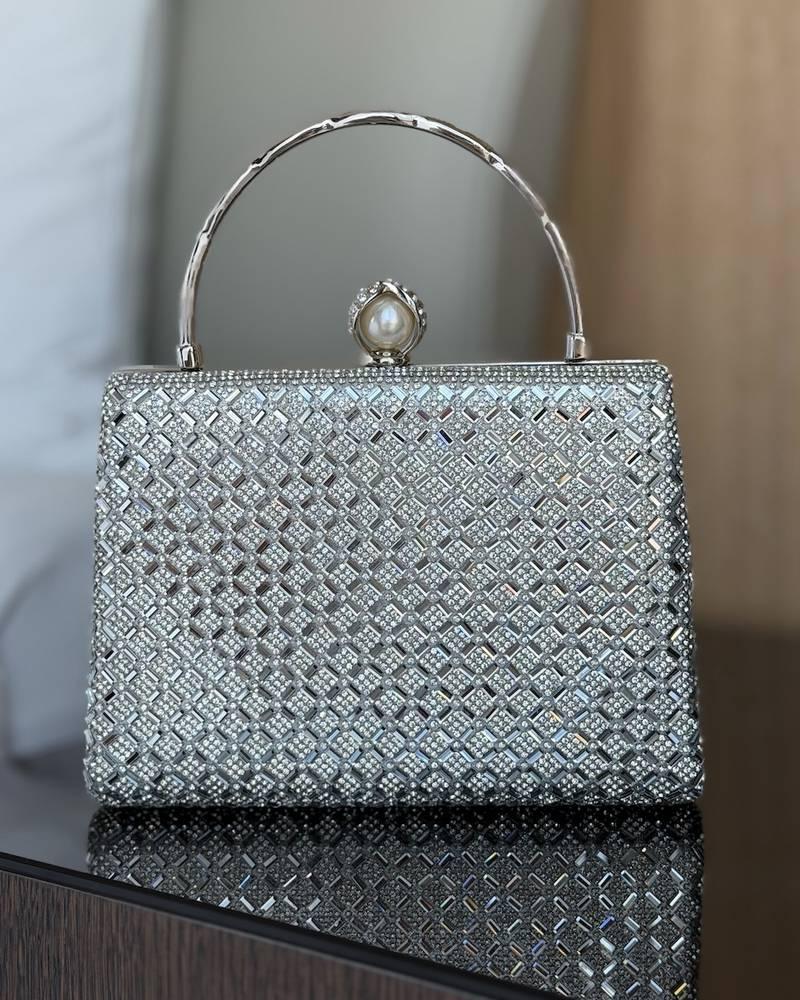 Evening bag with a round handle decorated with a pearl