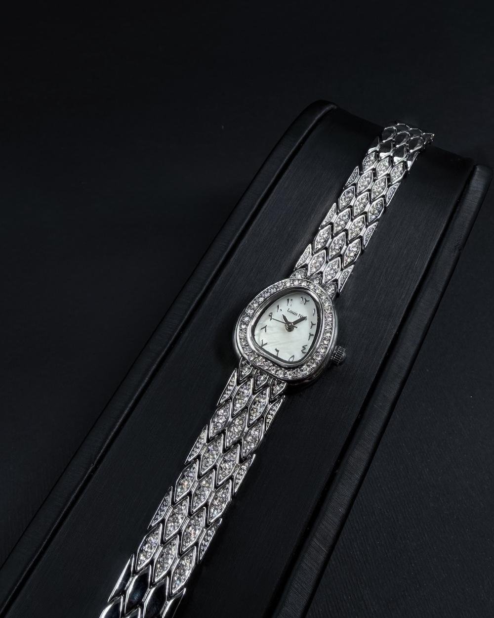 A luxury watch with a geometrically designed studded bracelet.