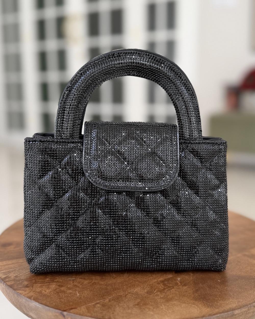 A square-shaped handbag with a stylish wide handle.