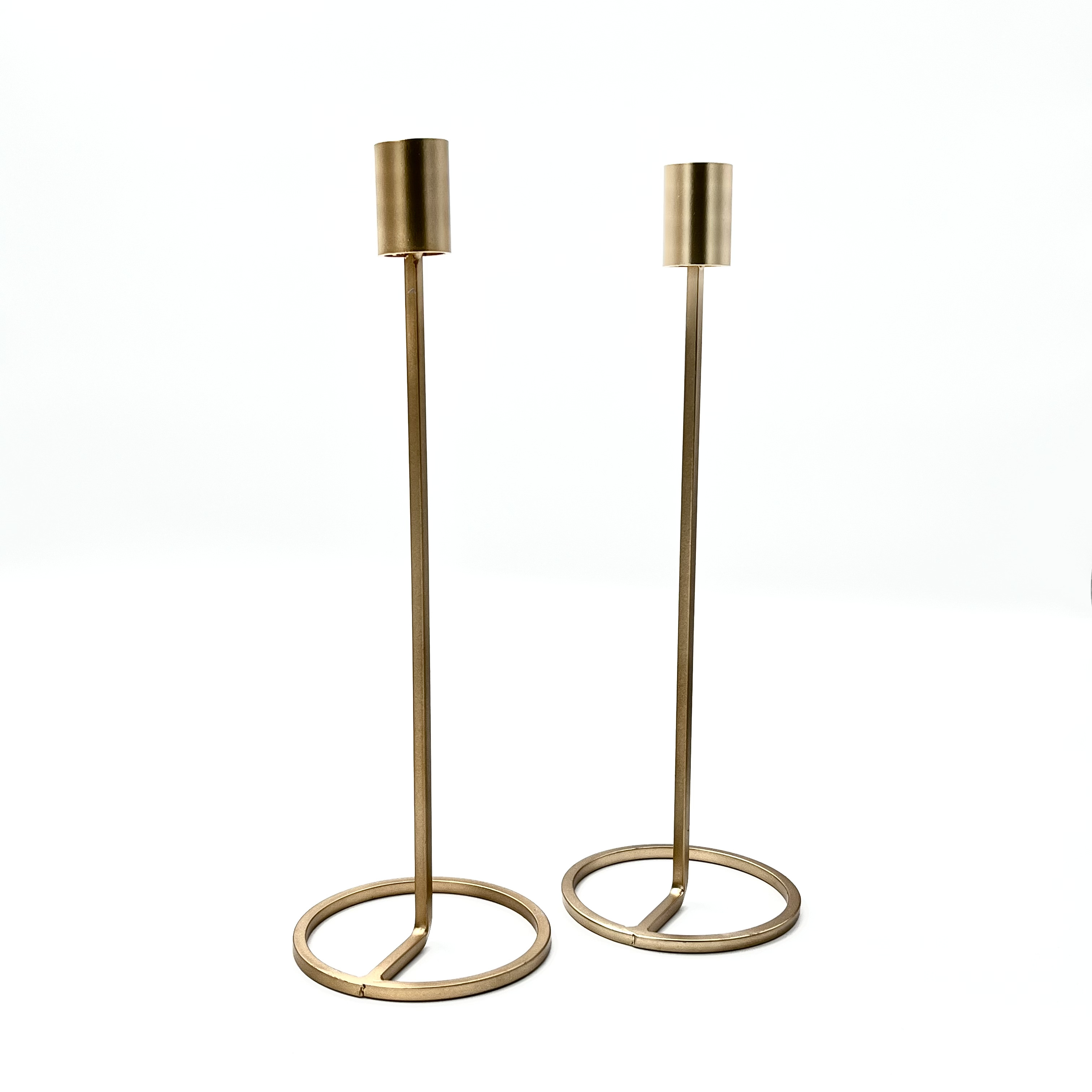 A set of two tall gold metal candle holders