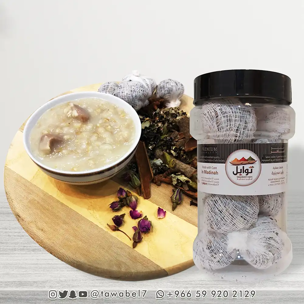 عبوة صرر بهارات الشوربة بجانب طبق هريس حجازي مع توابل كاملة وورد مجفف على لوح خشبي دائري
