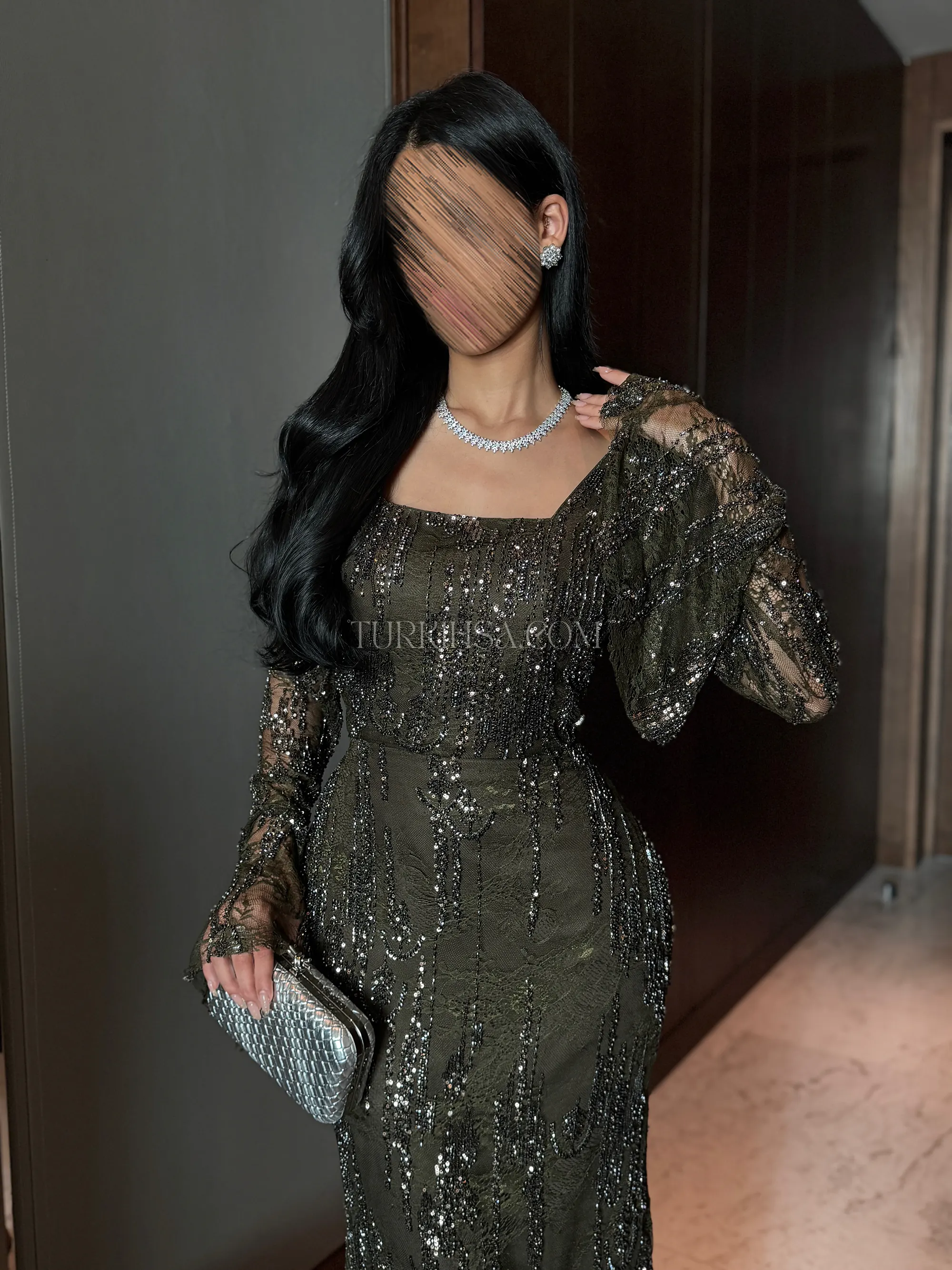 لقطة متوسطة (نصفية) تركز على الياقة المربعة الأنيقة (Square Neckline) التي تبرز جمال العنق والأكتاف، وتظهر دقة التطريزات اللامعة المتدفقة بشكل طولي على الصدر.