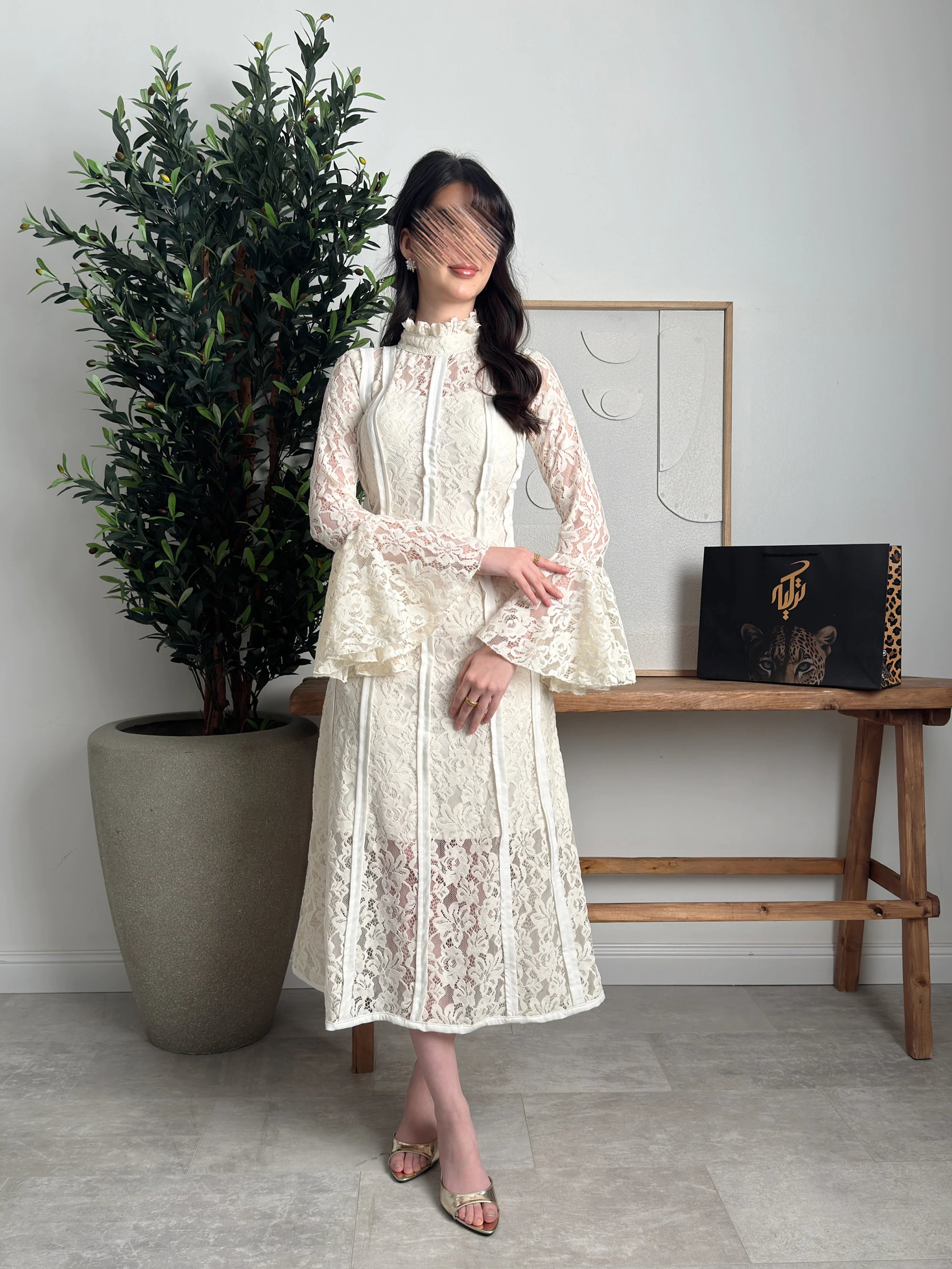 إطلالة كاملة تبرز رقي الدانتيل الأوف وايت وتصميم الأكمام الجرس (Bell Sleeves) الفاخر مع طول الميدي الأنيق.