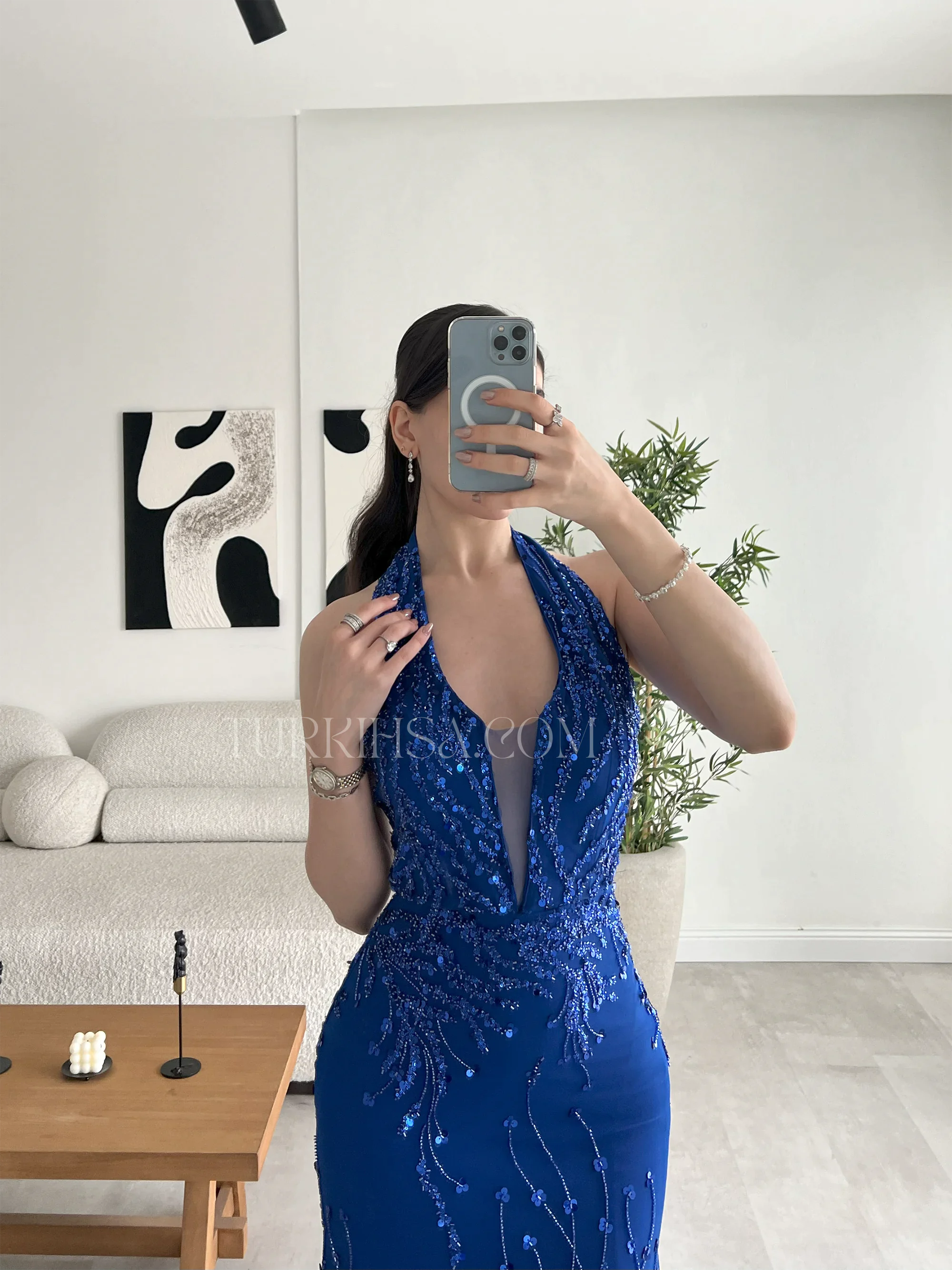 تفصيل دقيق للياقة المصممة بأسلوب الرسن (Halter Neck) مع تصميم الصدر الجريء المزود بتل شفاف، مما يبرز دقة وحرفية الشك اليدوي بالخرز.