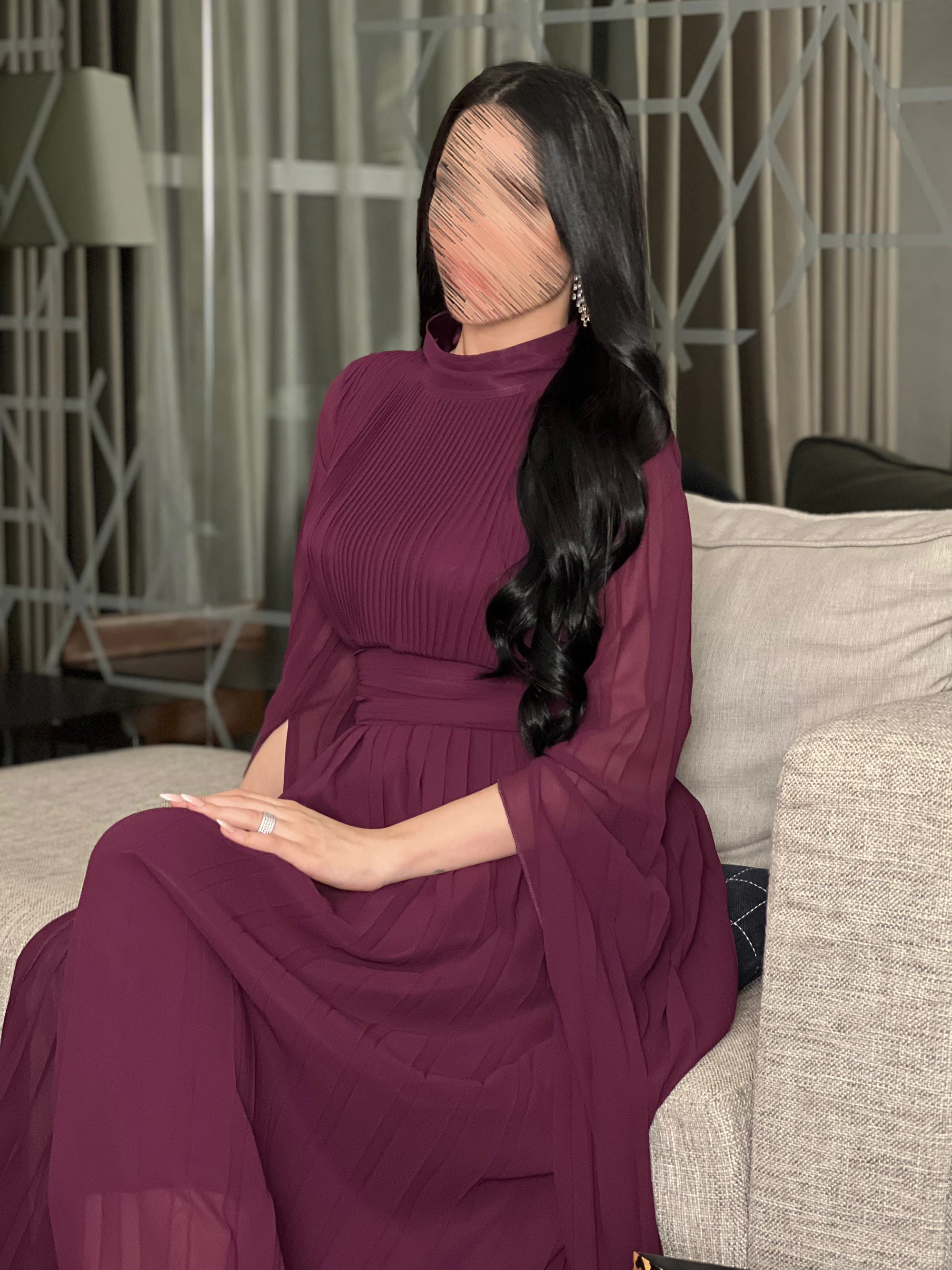 وضعية جلوس تعكس انسيابية قماش الجورجيت وكيفية تداخل الأكمام الطويلة مع حركة الجسم