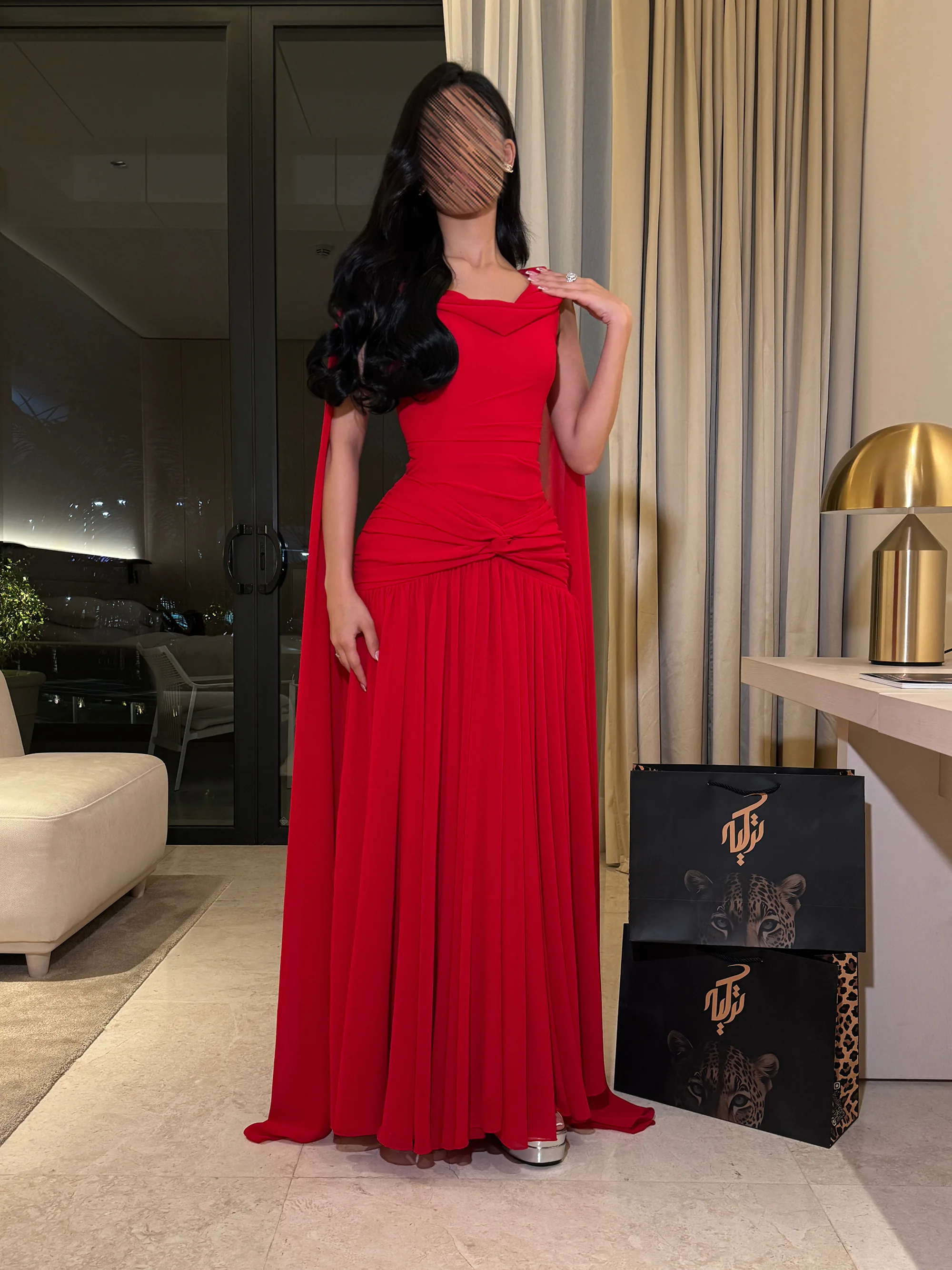 سحر اللون الأحمر الجذاب مع انسيابية الشيفون الفاخر، وجمال الوشاح المنسدل من الأكتاف كالكاب ليضفي طابعاً ملكياً مبهراً في السهرات.