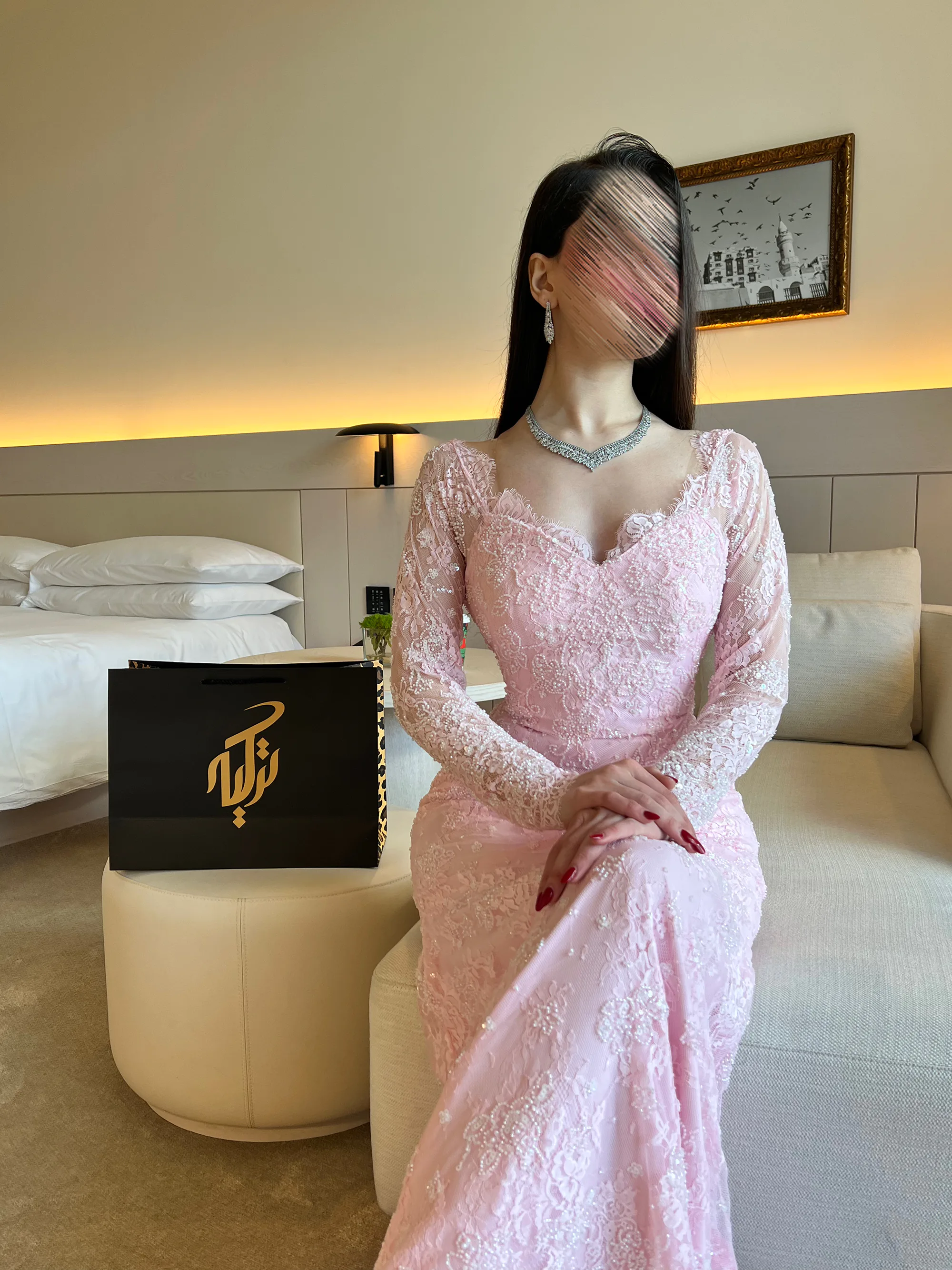 طلالة بوضعية الجلوس تعكس رقي التصميم، وتبرز تناسق الأكمام الطويلة المطرزة مع تفاصيل الصدرية والياقة الجذابة.