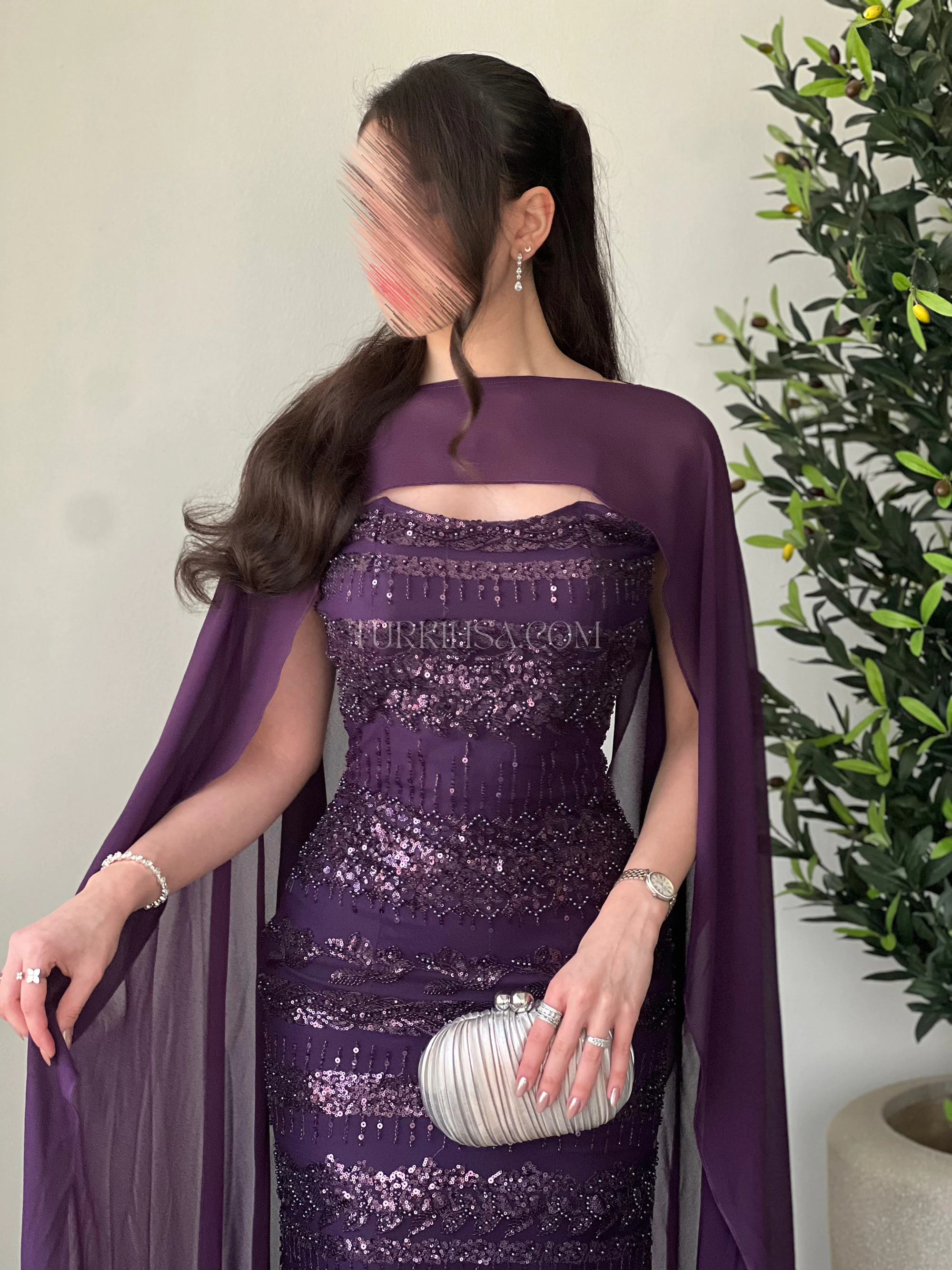 لقطة بوضعية الوقوف تبرز حركة الكايب الخفيف حول الذراعين وتفاصيل التطريز اليدوي على أطرافه، مع تنسيق حقيبة متجر 