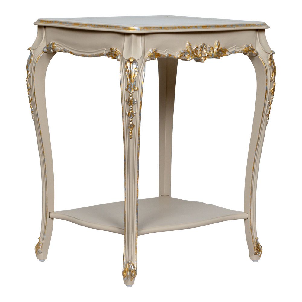 Luxurious classic beige side table adorned with gold details and intricate carvings on the top and legs and a lower shelf