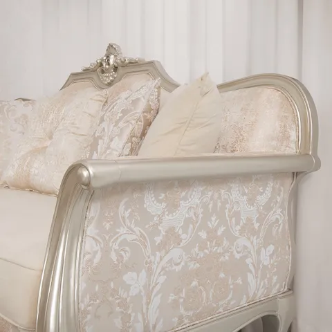صورة مقربة لكنبة ثلاثية بزخارف فضية مع تنجيد عاجي أنيق