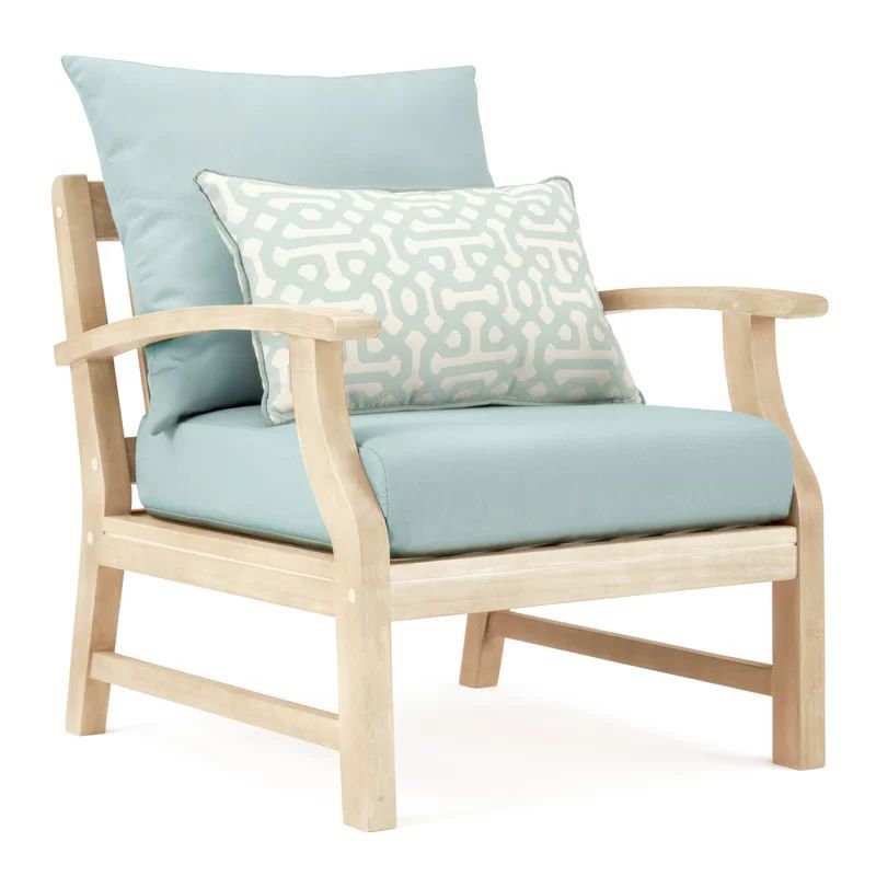 Closeup of wooden chairs with blue cushions and patterned pillow