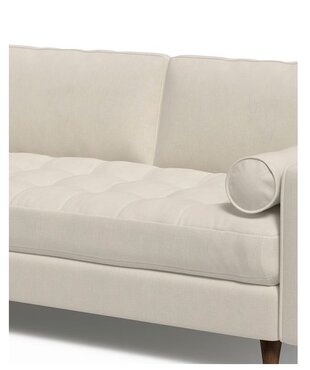 صورة مقربة لكنبة زاوية باللون الأوف وايت مع وسائد مريحة وتصميم أنيق