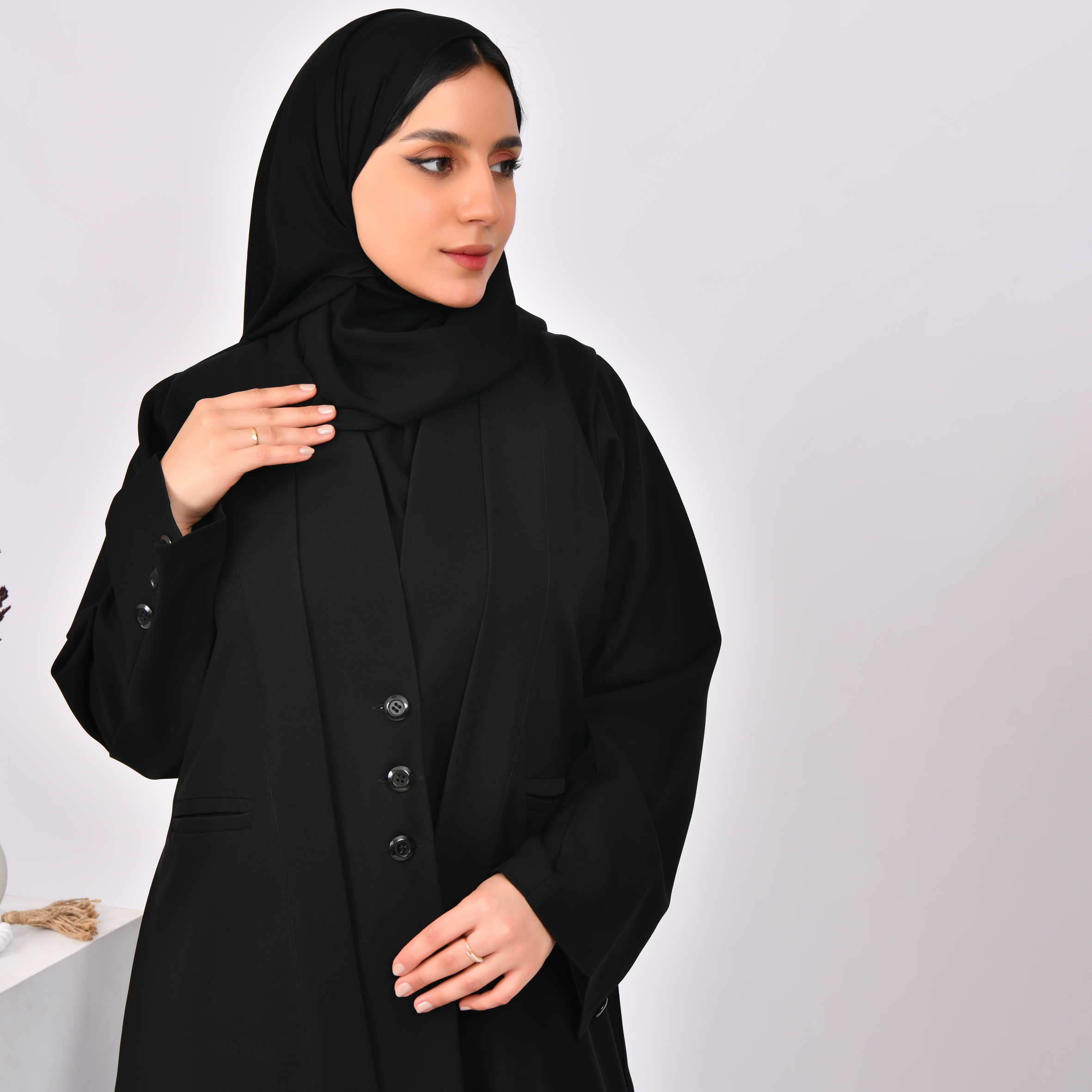  عباية سوداء تصميم بليزر بكتفايات مغلقة بأزرار وجيوب جانبية  