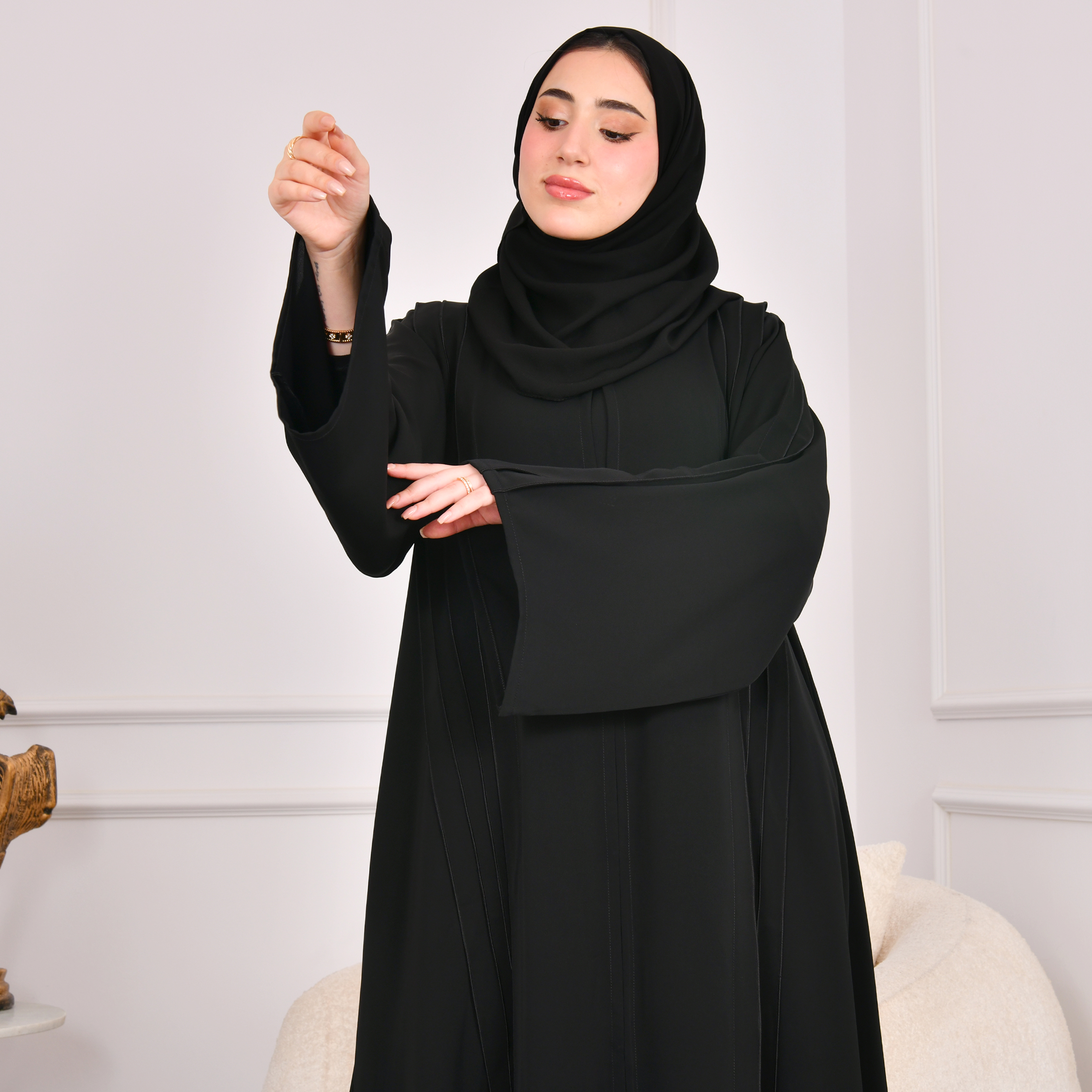  عباية سوداء كلوش تصميم اماراتي مغلقة بكم واسع وكسرات على جانبي العباية مع كسرات مزينة بازرار من الخلف 