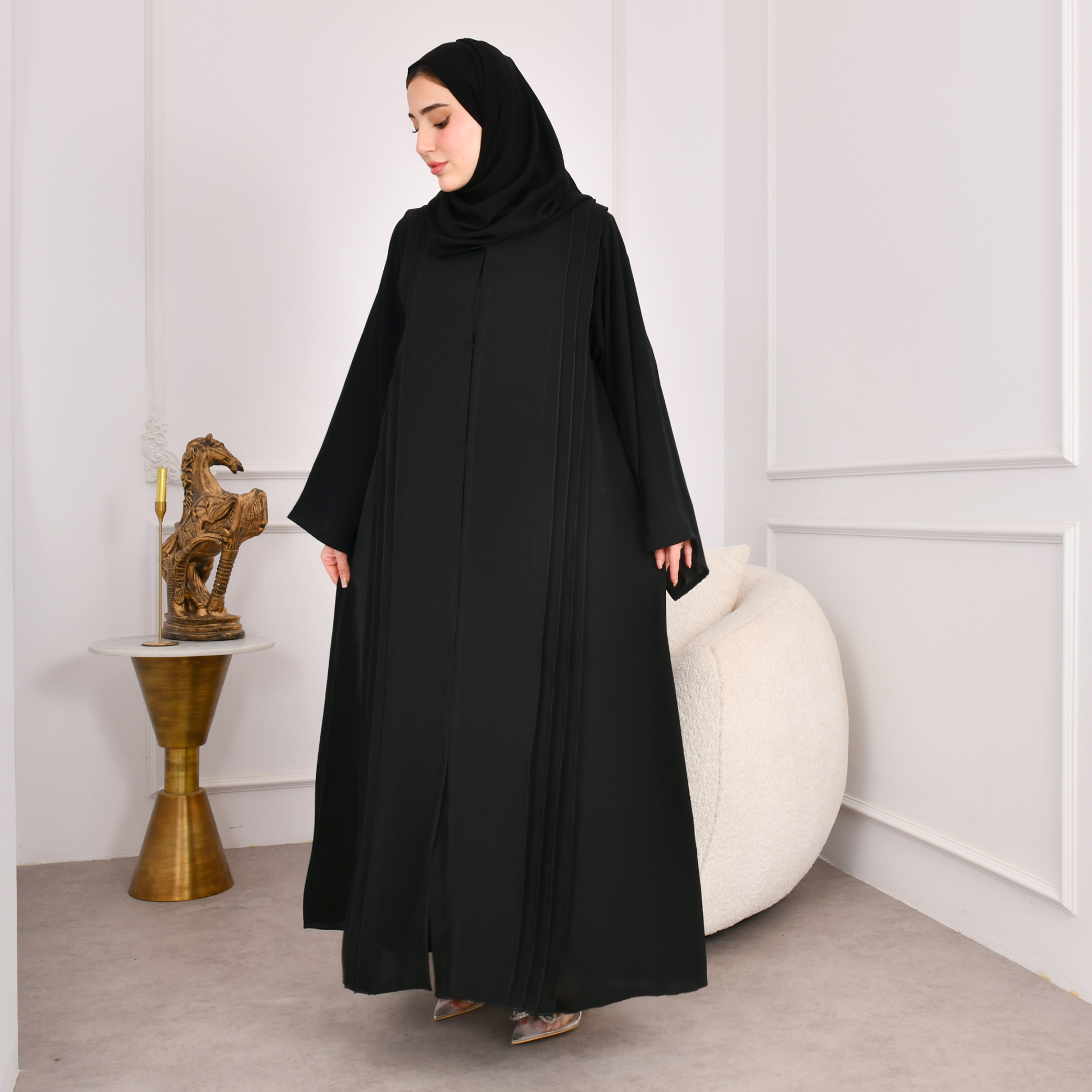  عباية سوداء كلوش تصميم اماراتي مغلقة بكم واسع وكسرات على جانبي العباية مع كسرات مزينة بازرار من الخلف 