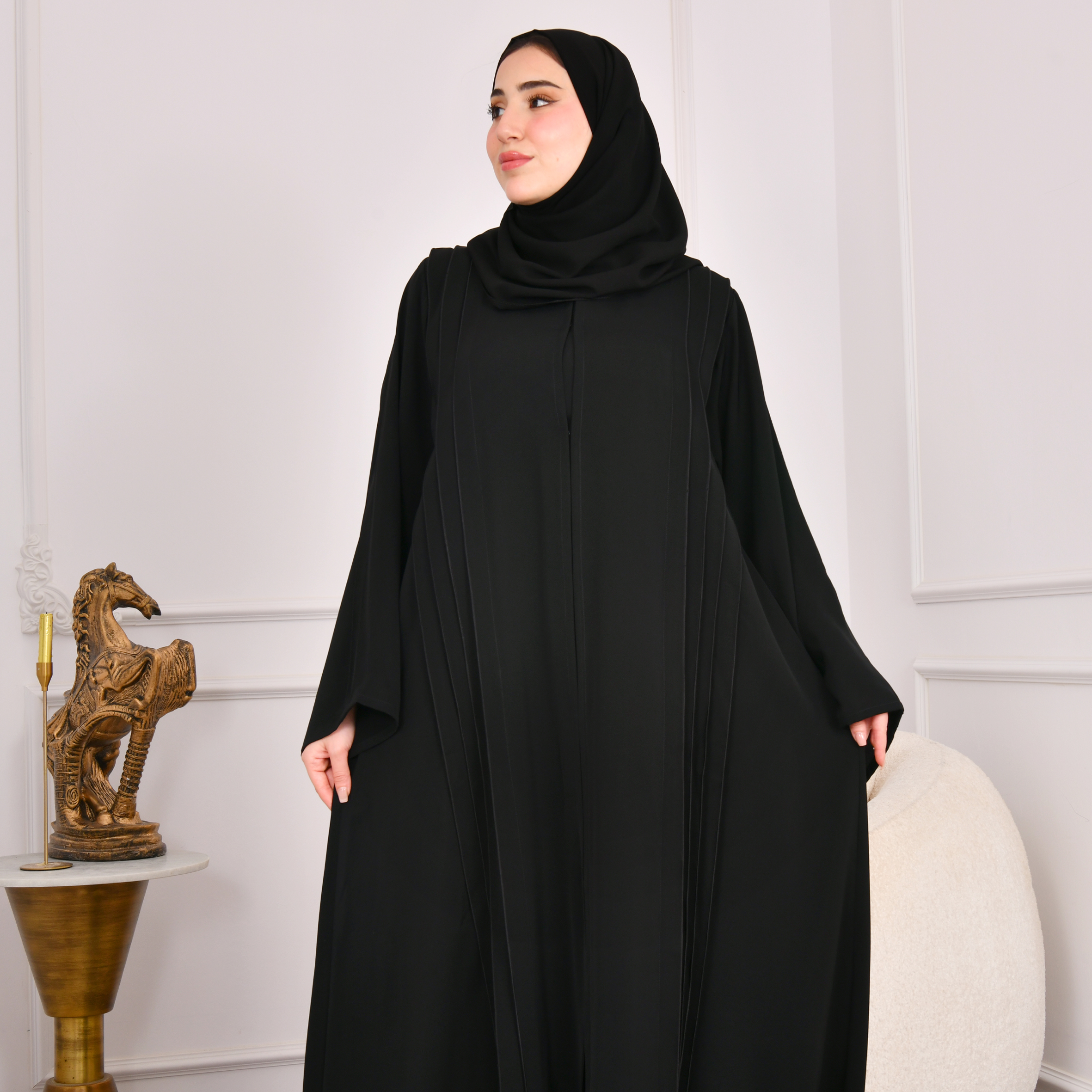 عباية سوداء كلوش تصميم اماراتي مغلقة بكم واسع وكسرات على جانبي العباية مع كسرات مزينة بازرار من الخلف 