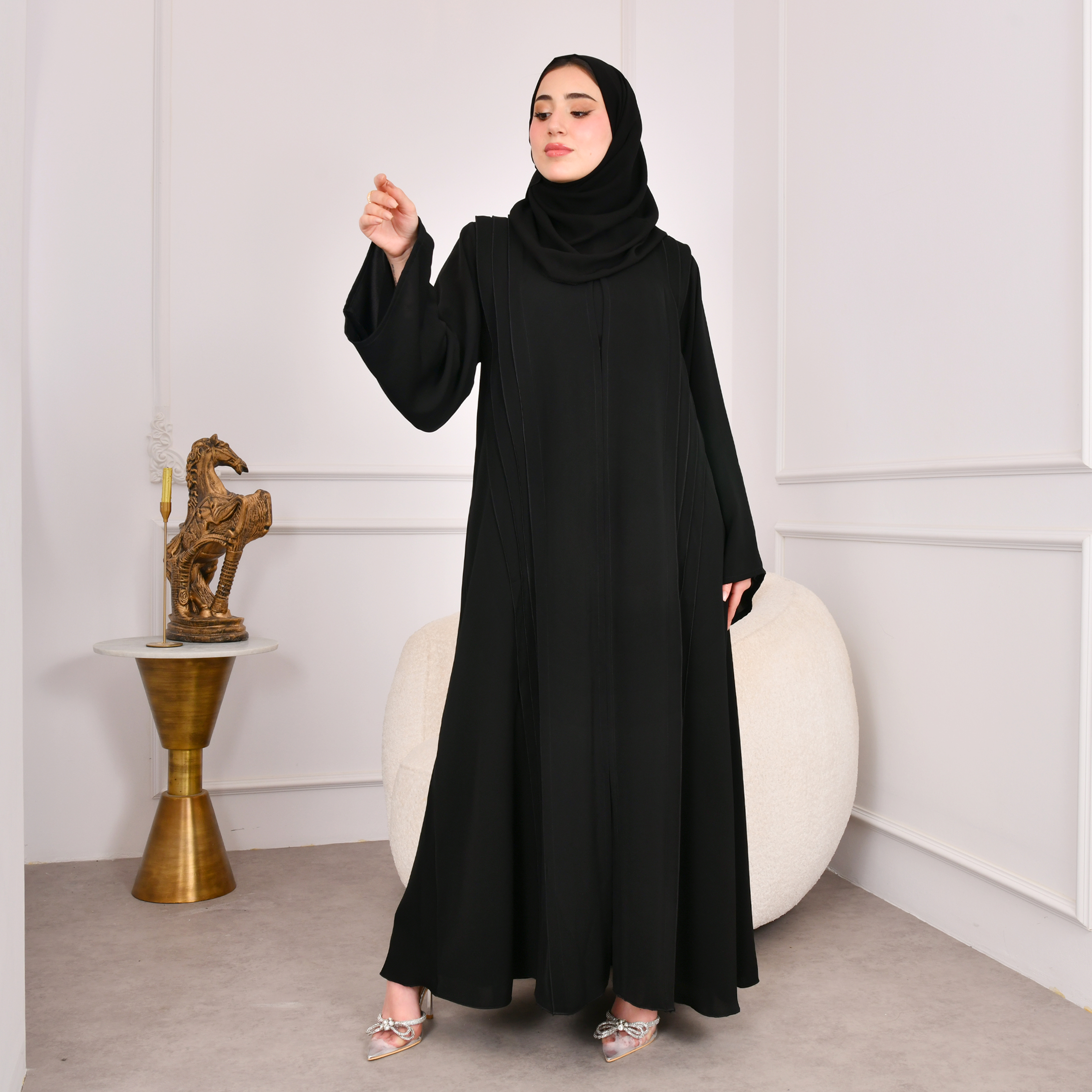  عباية سوداء كلوش تصميم اماراتي مغلقة بكم واسع وكسرات على جانبي العباية مع كسرات مزينة بازرار من الخلف 