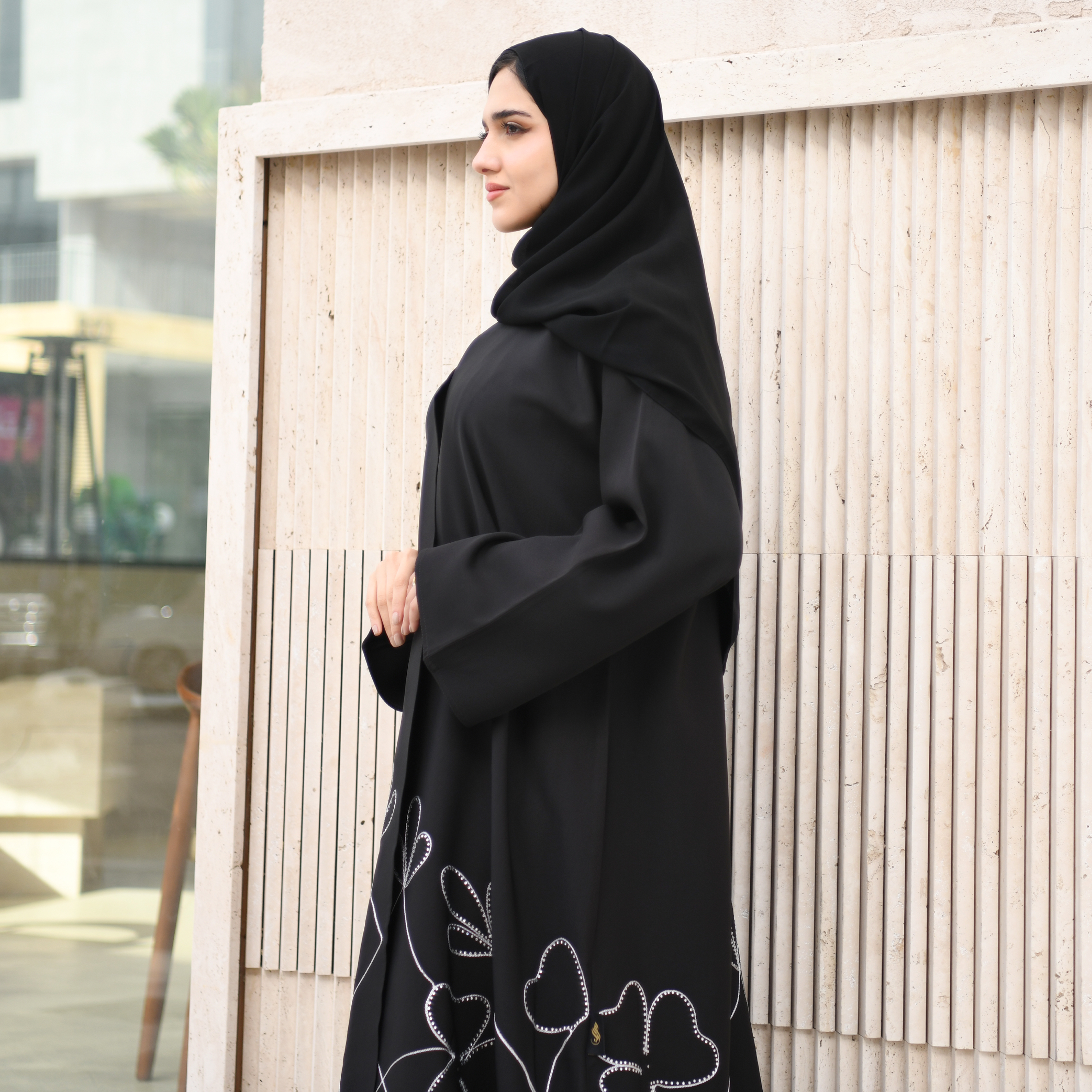  عباية ربع كلوش سوداء بقماش راكز مزينة بتطريز وفصوص باللون الأبيض من الاسفل  مع زر اغلاق  