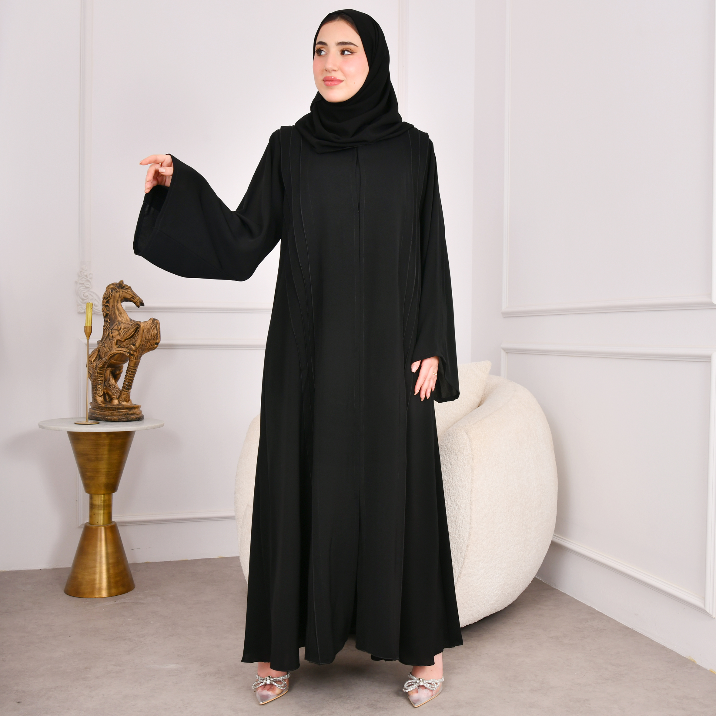  عباية سوداء كلوش تصميم اماراتي مغلقة بكم واسع وكسرات على جانبي العباية مع كسرات مزينة بازرار من الخلف 