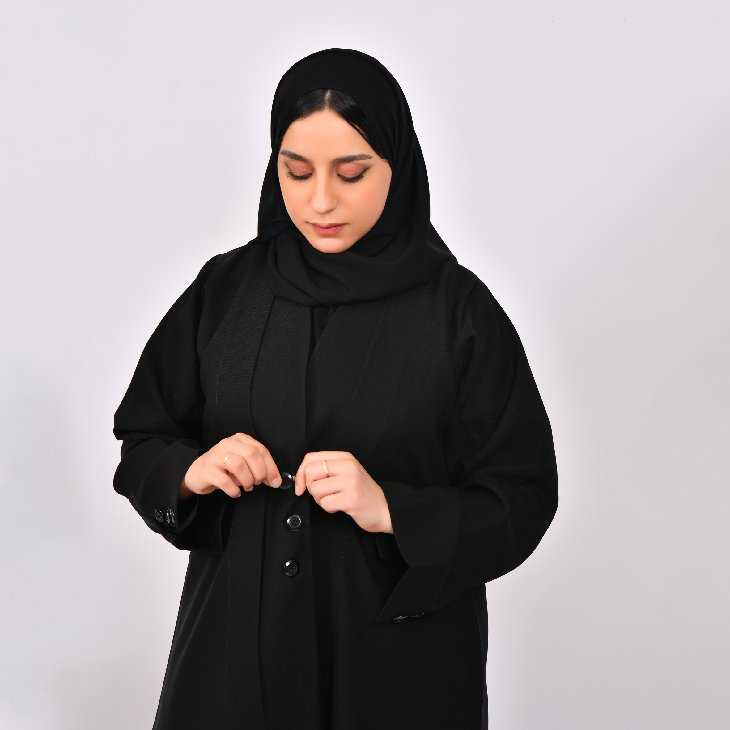  عباية سوداء تصميم بليزر بكتفايات مغلقة بأزرار وجيوب جانبية  