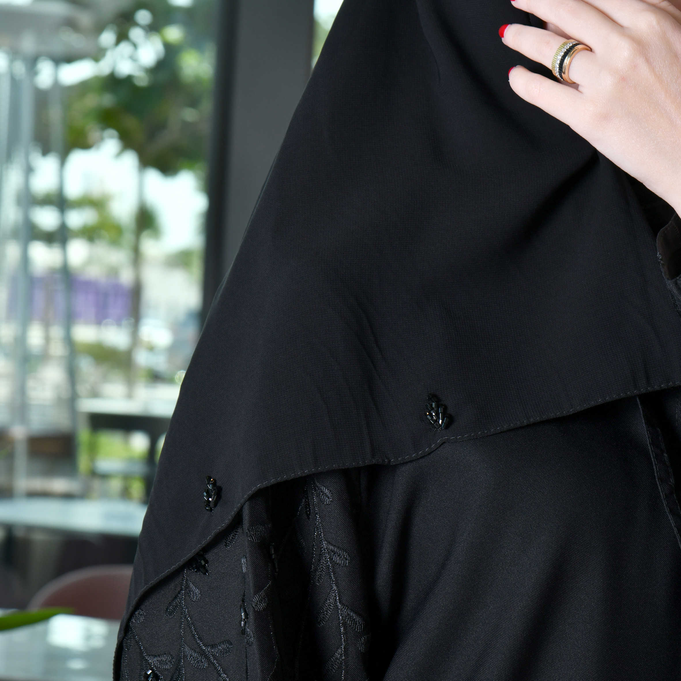 عباية لف سوداء مع تطريز وشك بارز على الأكمام 