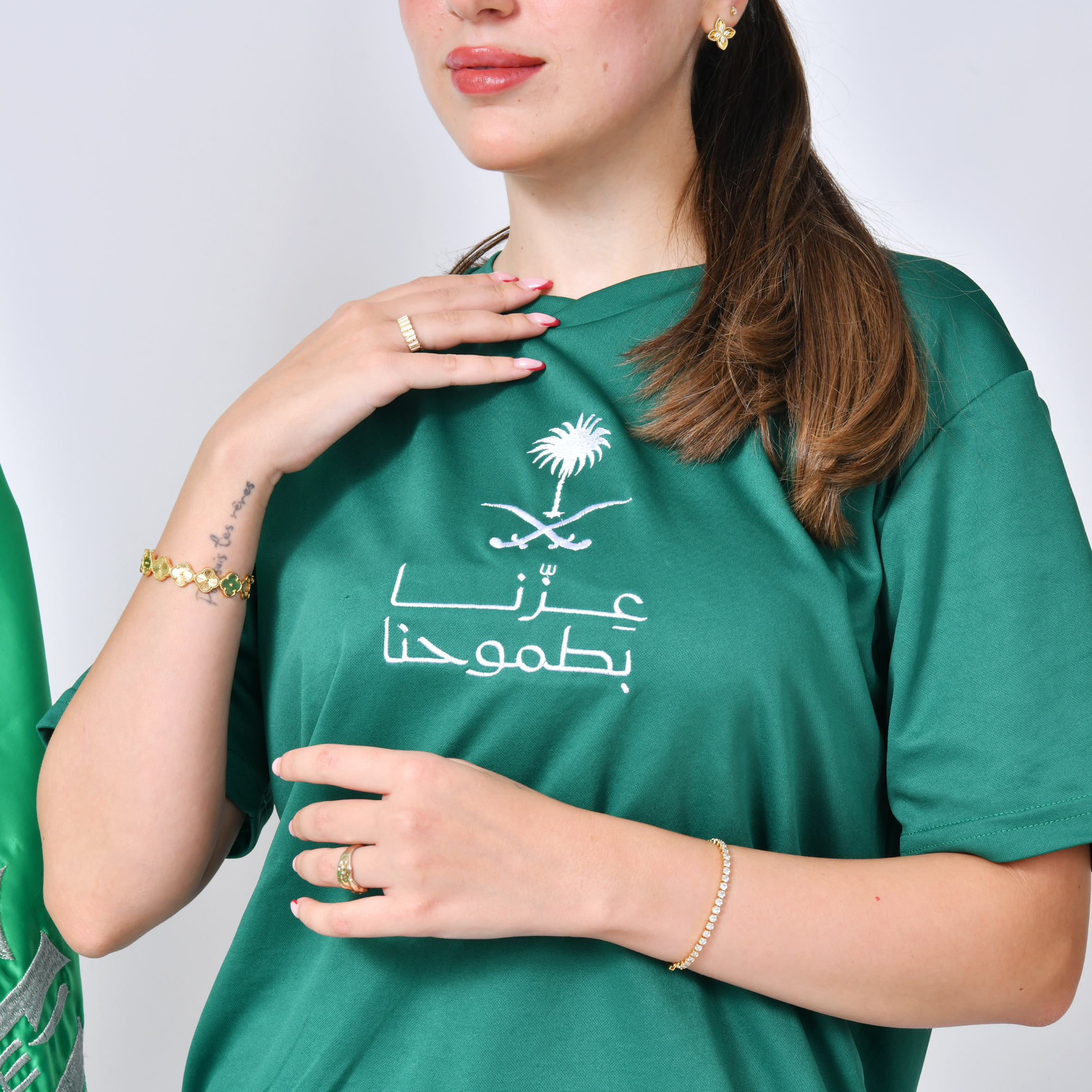  تيشيرت أخضر بتطريز شعار عزنا بطموحنا مع سدو من الخلف  