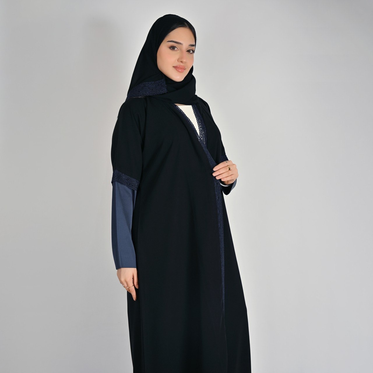  عباية سوداء بقصة انسيابية بأكمام ساتان كحلي ولمسات دانتيل 