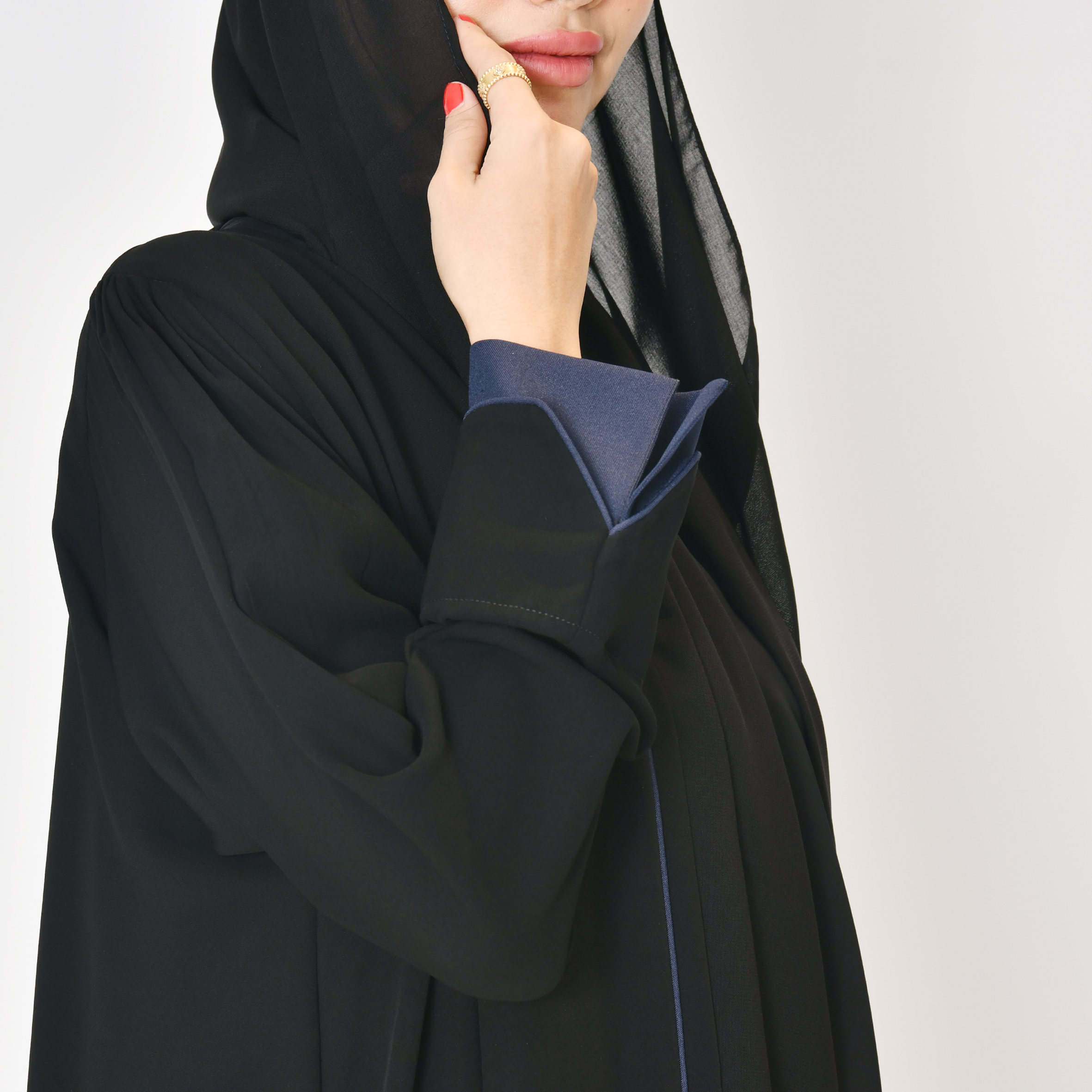  عباية لف سوداء بقماش ربع كلوش بأكمام بڤ  و تداخل اللون الكحلي على الاكمام واطراف العباية الامامية والجانبية بشكل سهمي  