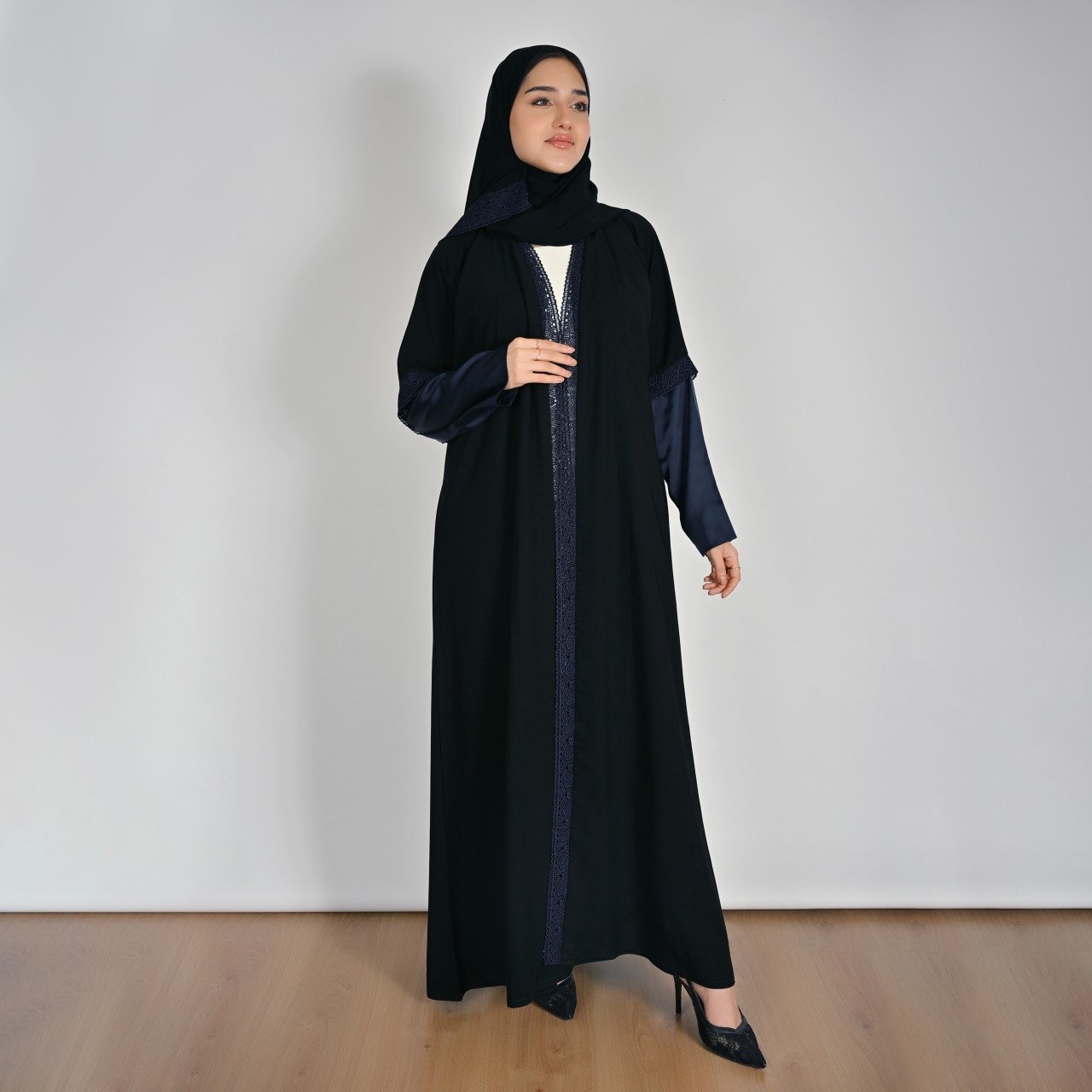  عباية سوداء بقصة انسيابية بأكمام ساتان كحلي ولمسات دانتيل 