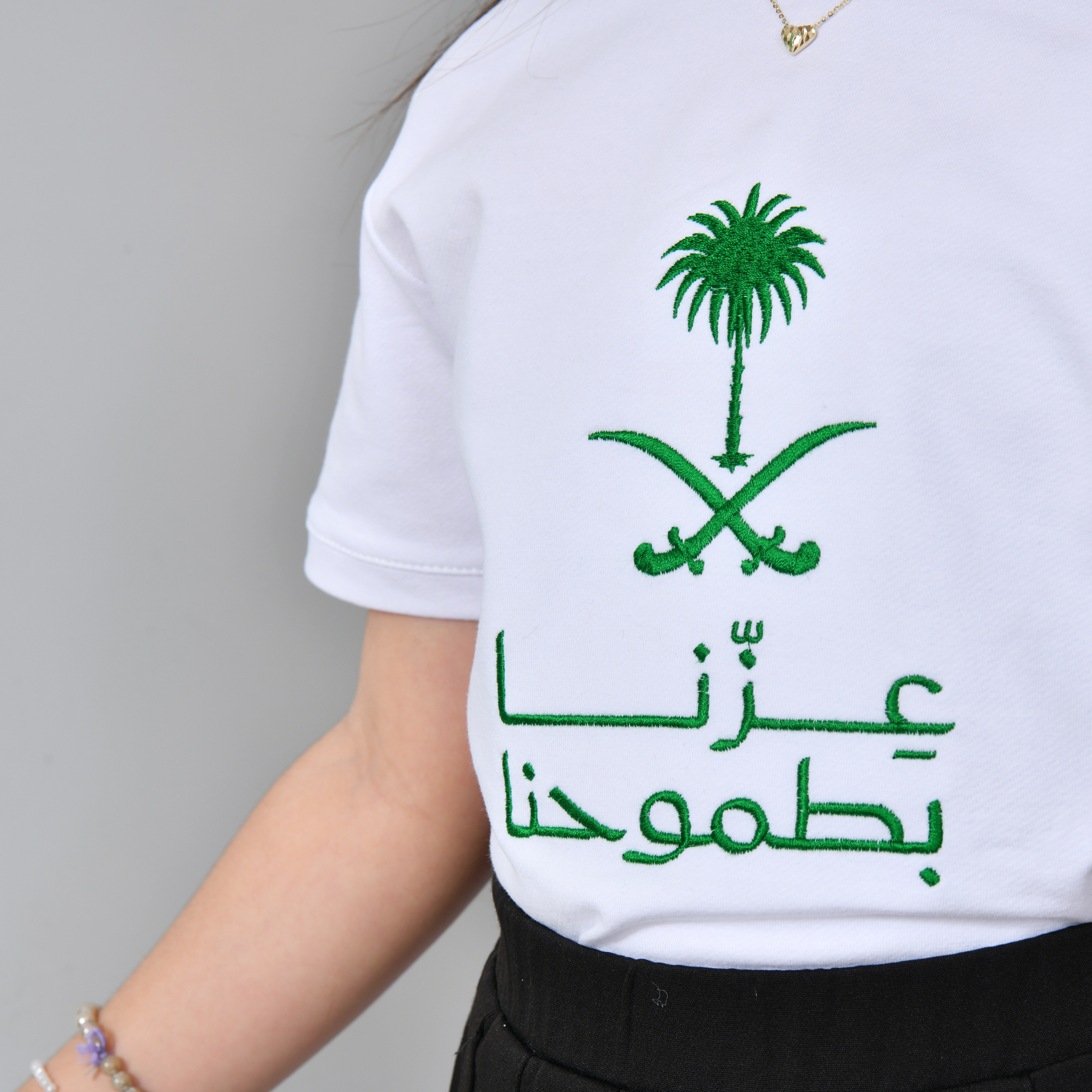  تيشيرت ابيض بتطريز شعار عزنا بطموحنا (للأولاد والبنات) 