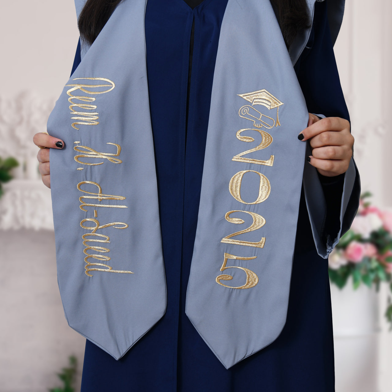  زي التخرج باللون الكحلي الداكن وتداخل اللون الرمادي على الاكمام مع وشاح وكاب سادة  