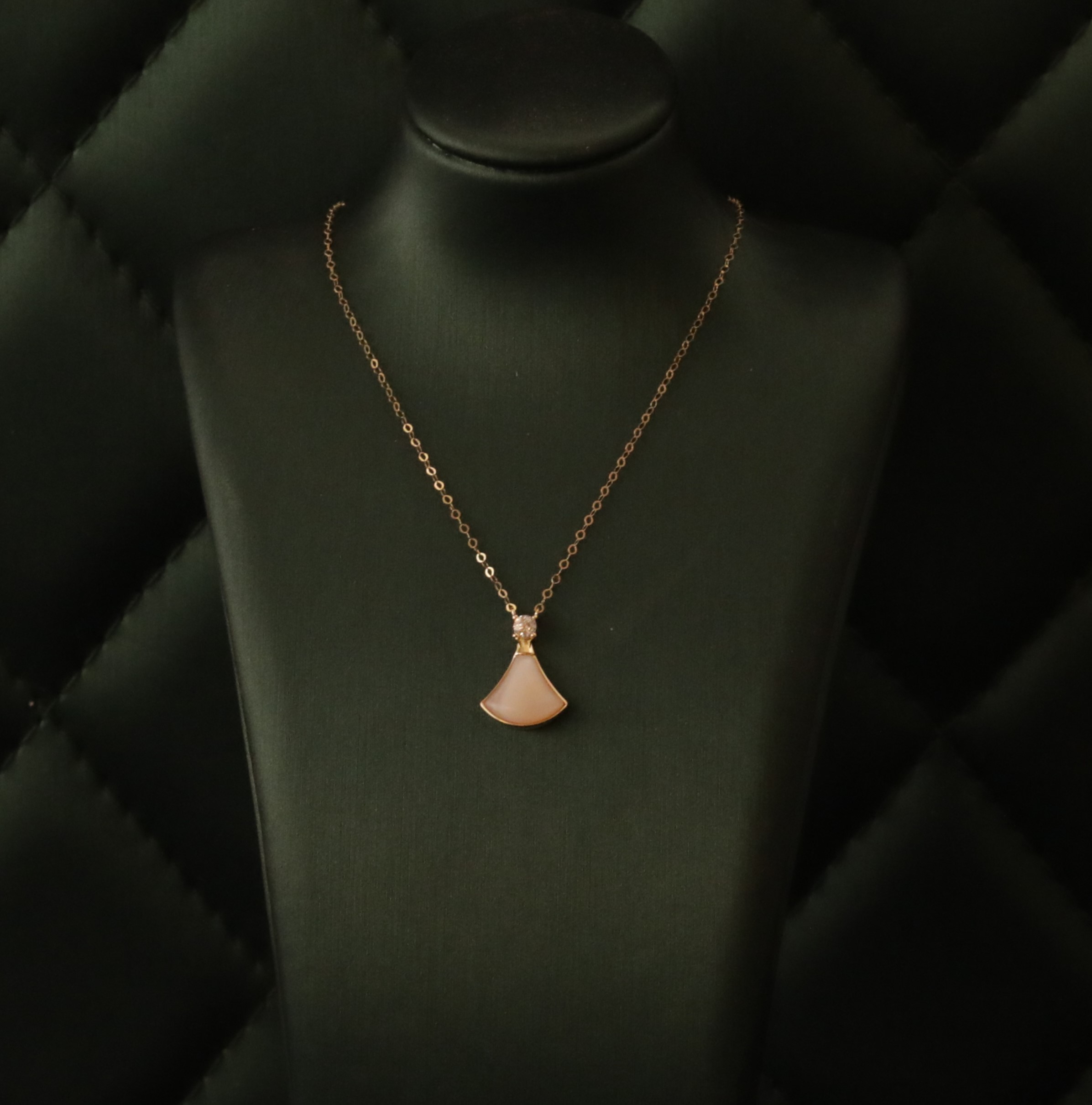Gold necklace with pink gemstone charm