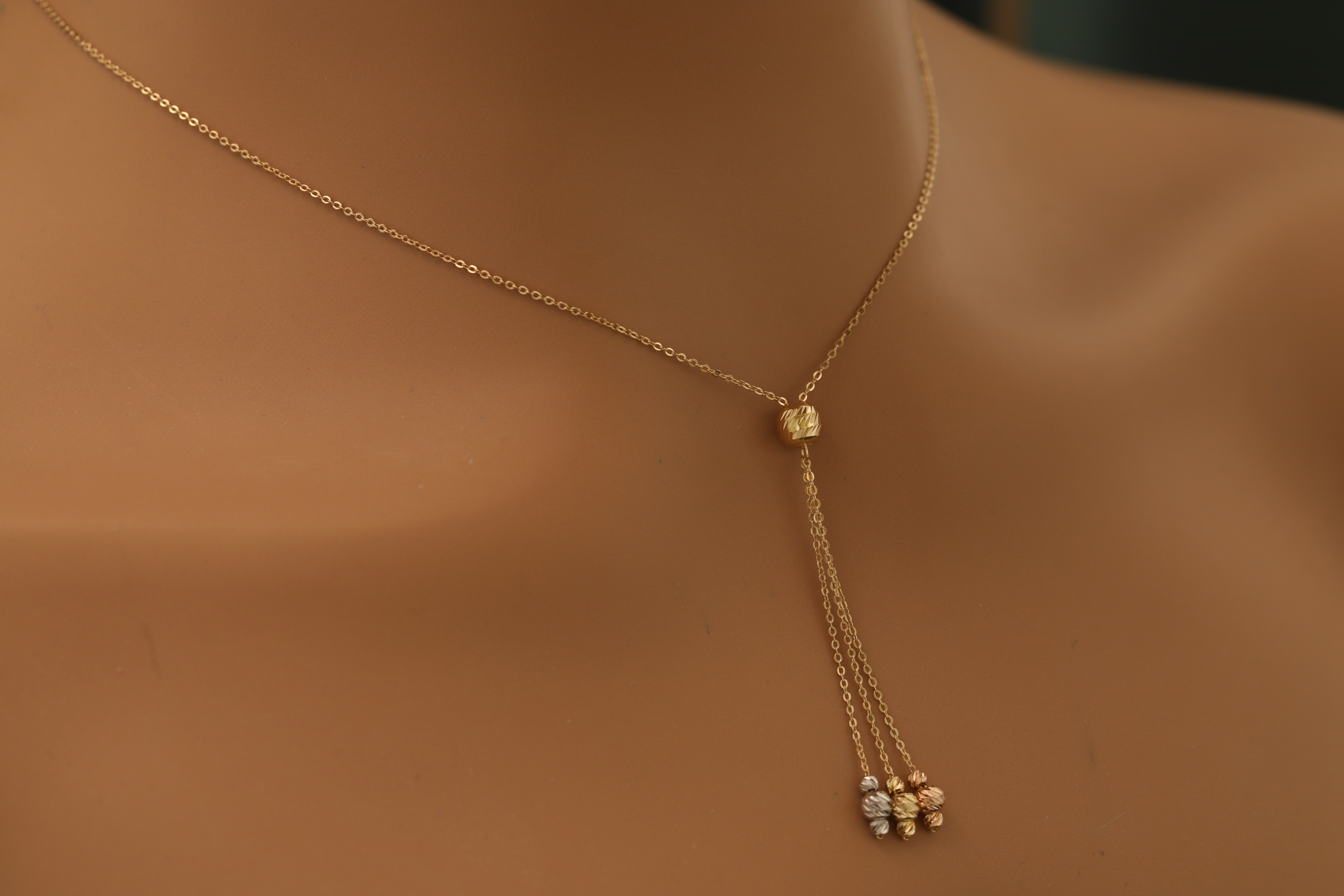 Long gold necklace with shiny gemstone