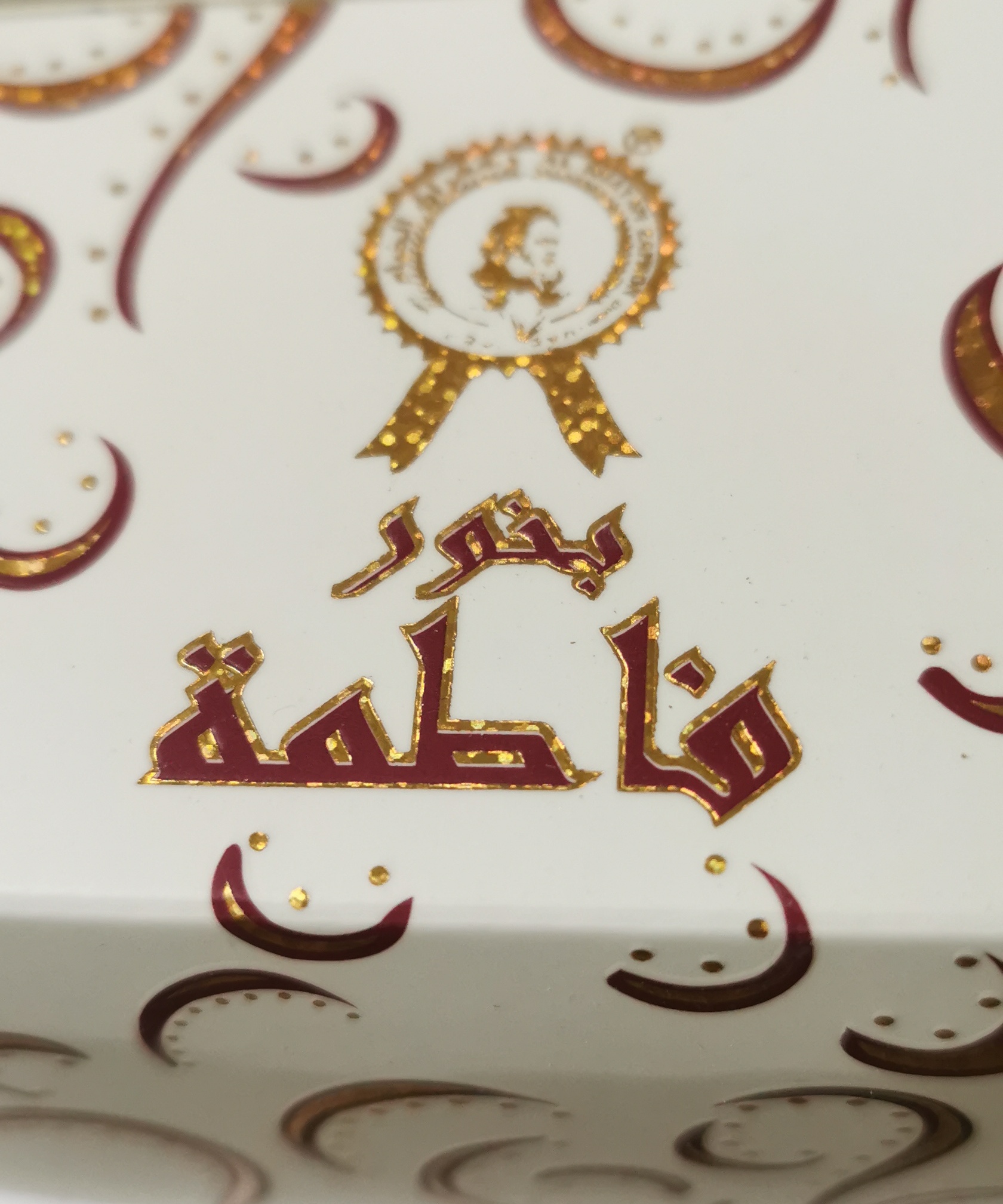 بخور فاطمة بخور عبوة بيضاء مزخرفة بنقوش ذهبية وحمراء