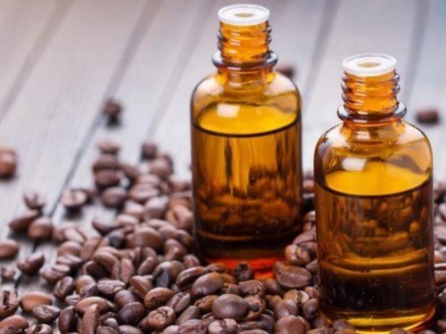 حبوب قهوة متناثرة مع زيت عطري