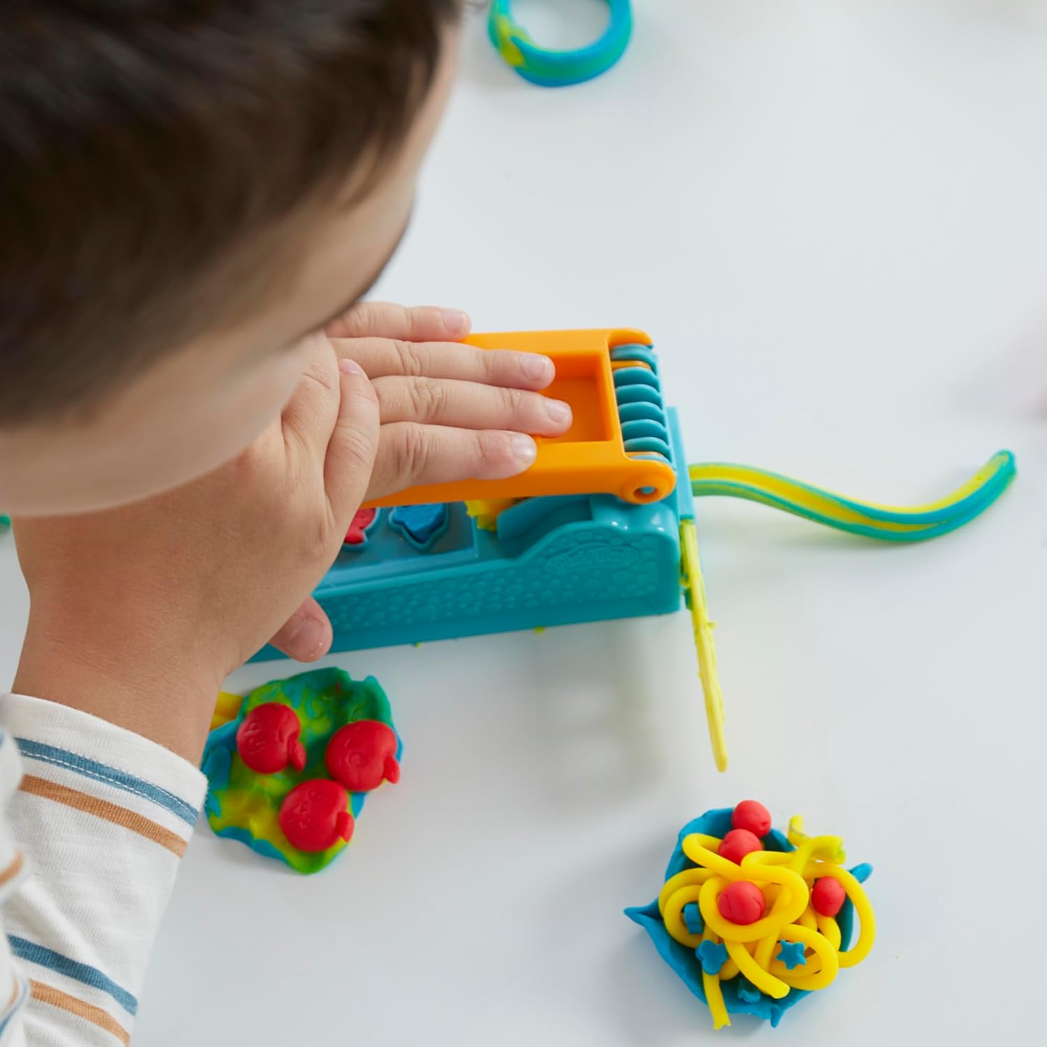 Child shaping colorful Play-Doh creation