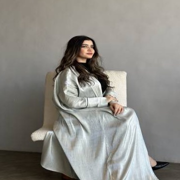 مودل ترتدي عباية بلون ميتاليك لامع بتصميم أنيق مع تفاصيل لامعة على الأكمام والأطراف