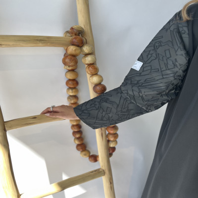 مودل ترتدي عباية سوداء بتصميم بليزر نص كلوش مع تفاصيل جاكار مشجر أنيقة على الأكمام