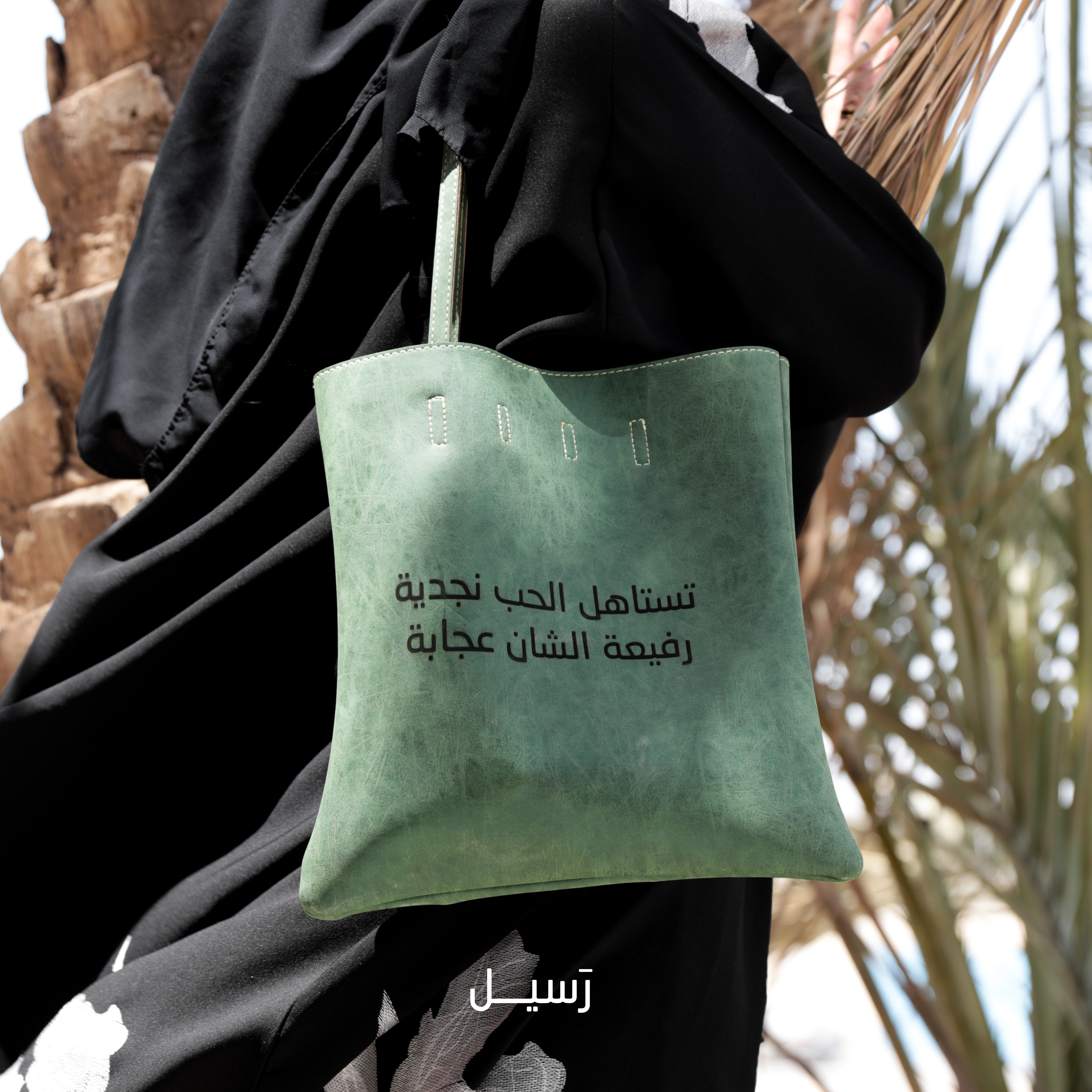 حقيبة نجدية جلدية خضراء محفور عليها بيت شعري