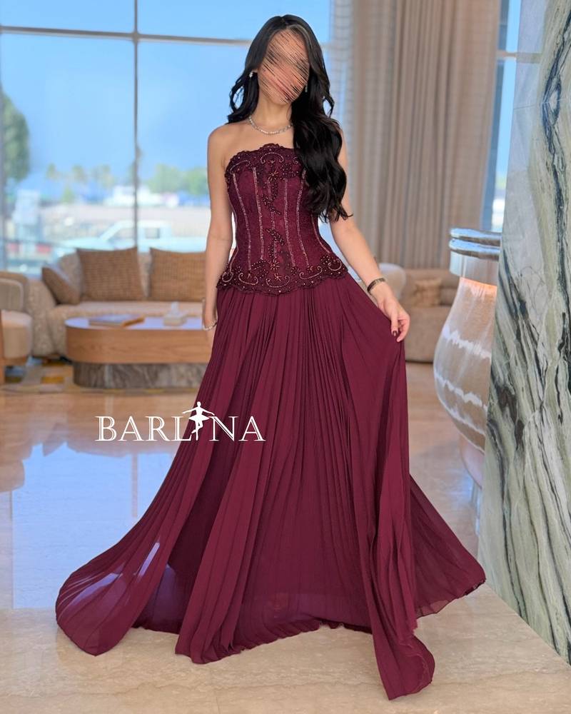 Burgundy dress with multiple pleats and a corset cut